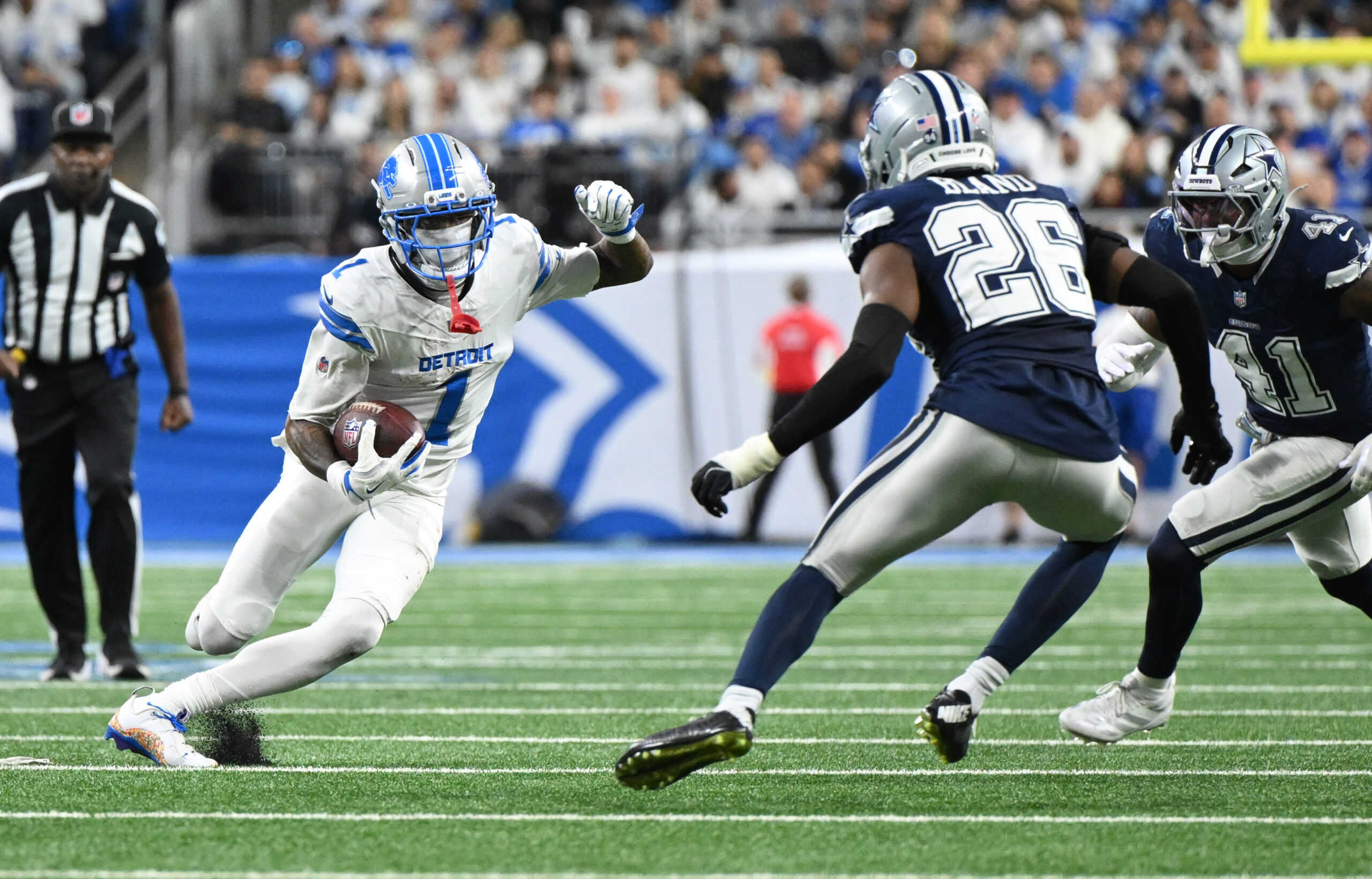 Dec 4, 2025; Detroit, Michigan, USA; Detroit Lions wide receiver Jameson Williams (1) runs against Dallas Cowboys cornerback DaRon Bland (26) and defensive end Donovan Ezeiruaku (41) during the second half at Ford Field. Mandatory Credit: Lon Horwedel-Imagn Images