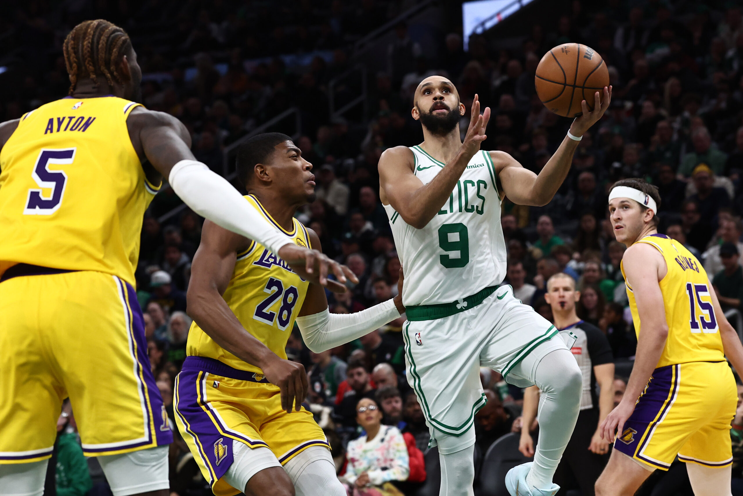 Dec 5, 2025; Boston, Massachusetts, USA; Boston Celtics guard Derrick White (9) goes to the basket past Los Angeles Lakers forward Rui Hachimura (28) during the second half at TD Garden. Mandatory Credit: Winslow Townson-Imagn Images