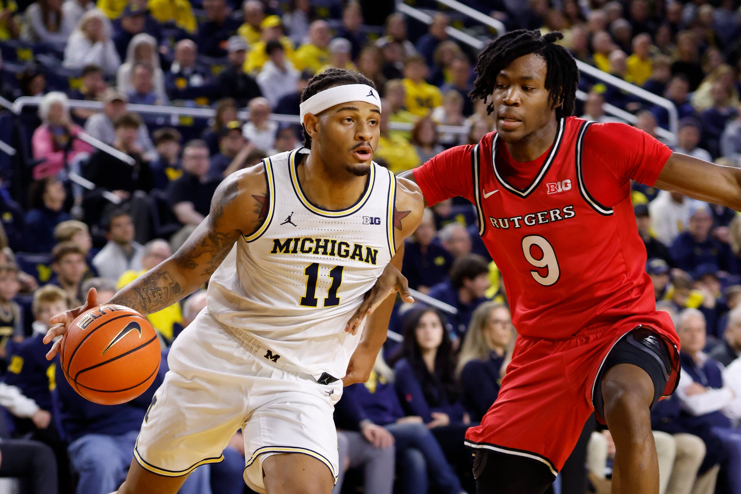 Dec 6, 2025; Ann Arbor, Michigan, USA;  Michigan Wolverines guard Roddy Gayle Jr. (11) dribbles defended by Rutgers Scarlet Knights forward Dylan Grant (9) in the first half at Crisler Center. Mandatory Credit: Rick Osentoski-Imagn Images