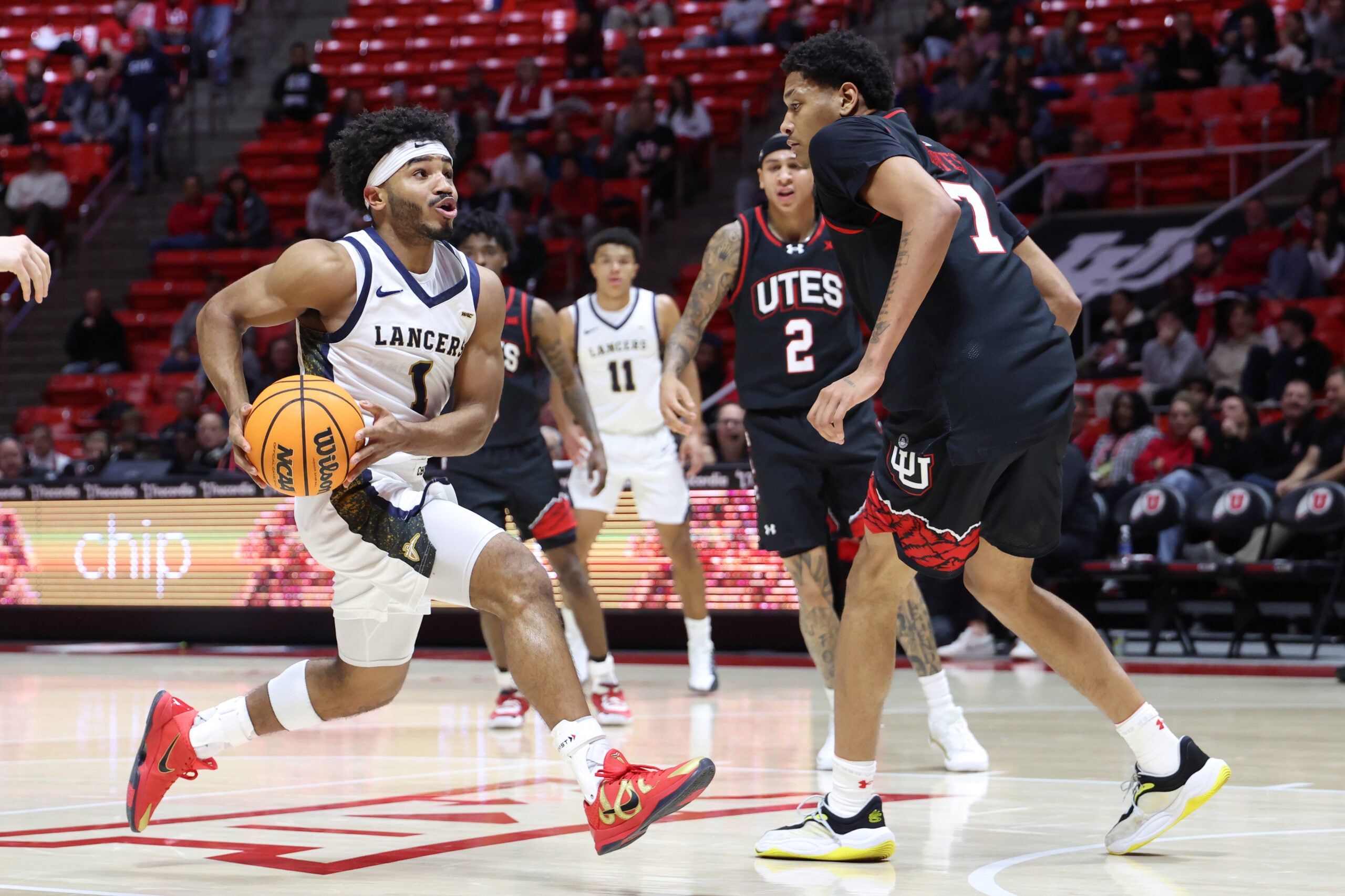 Dec 6, 2025; Salt Lake City, Utah, USA; California Baptist Lancers guard Dominique Daniels Jr. (1) drives to the basket against Utah Utes forward Josh Hayes (7) during the first half at Jon M. Huntsman Center. Mandatory Credit: Rob Gray-Imagn Images
