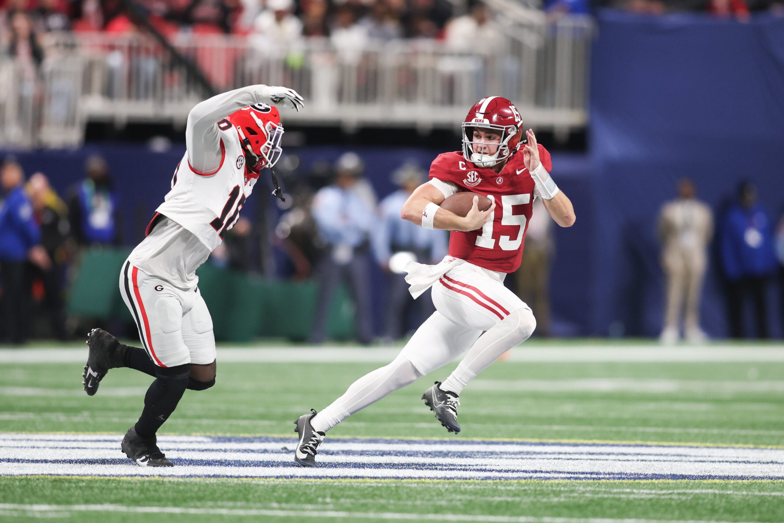 Dec 6, 2025; Atlanta, GA, USA; Alabama Crimson Tide quarterback Ty Simpson (15) rushes as Georgia Bulldogs linebacker Zayden Walker (10) defends during the fourth quarter during the 2025 SEC Championship game at Mercedes-Benz Stadium. Mandatory Credit: Brett Davis-Imagn Images