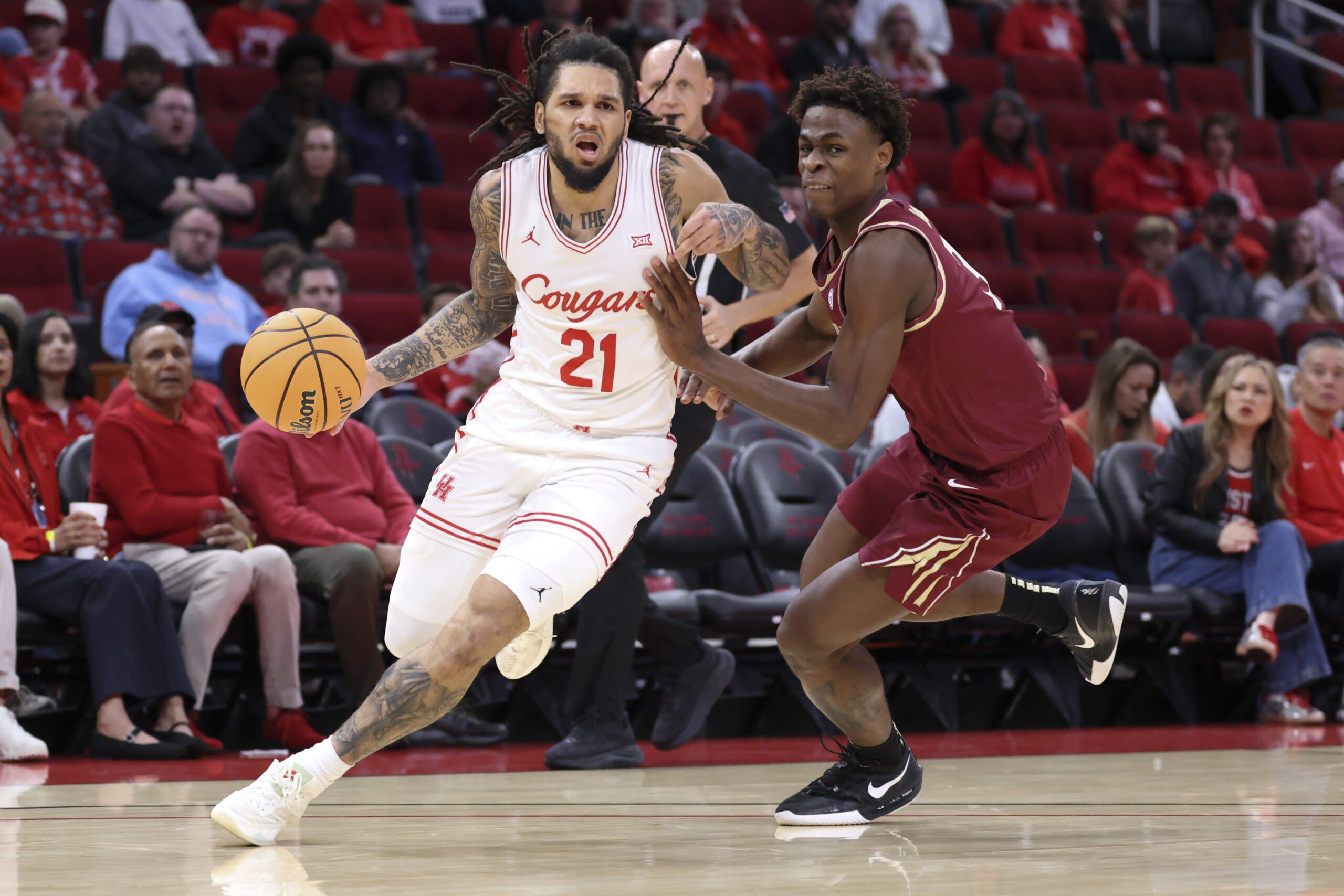 Dec 6, 2025; Houston, TX, USA; Houston Cougars guard Emanuel Sharp (21) dribbles the ball as Florida State Seminoles forward Thomas Bassong (3) defends during the first half at Toyota Center. Mandatory Credit: Troy Taormina-Imagn Images