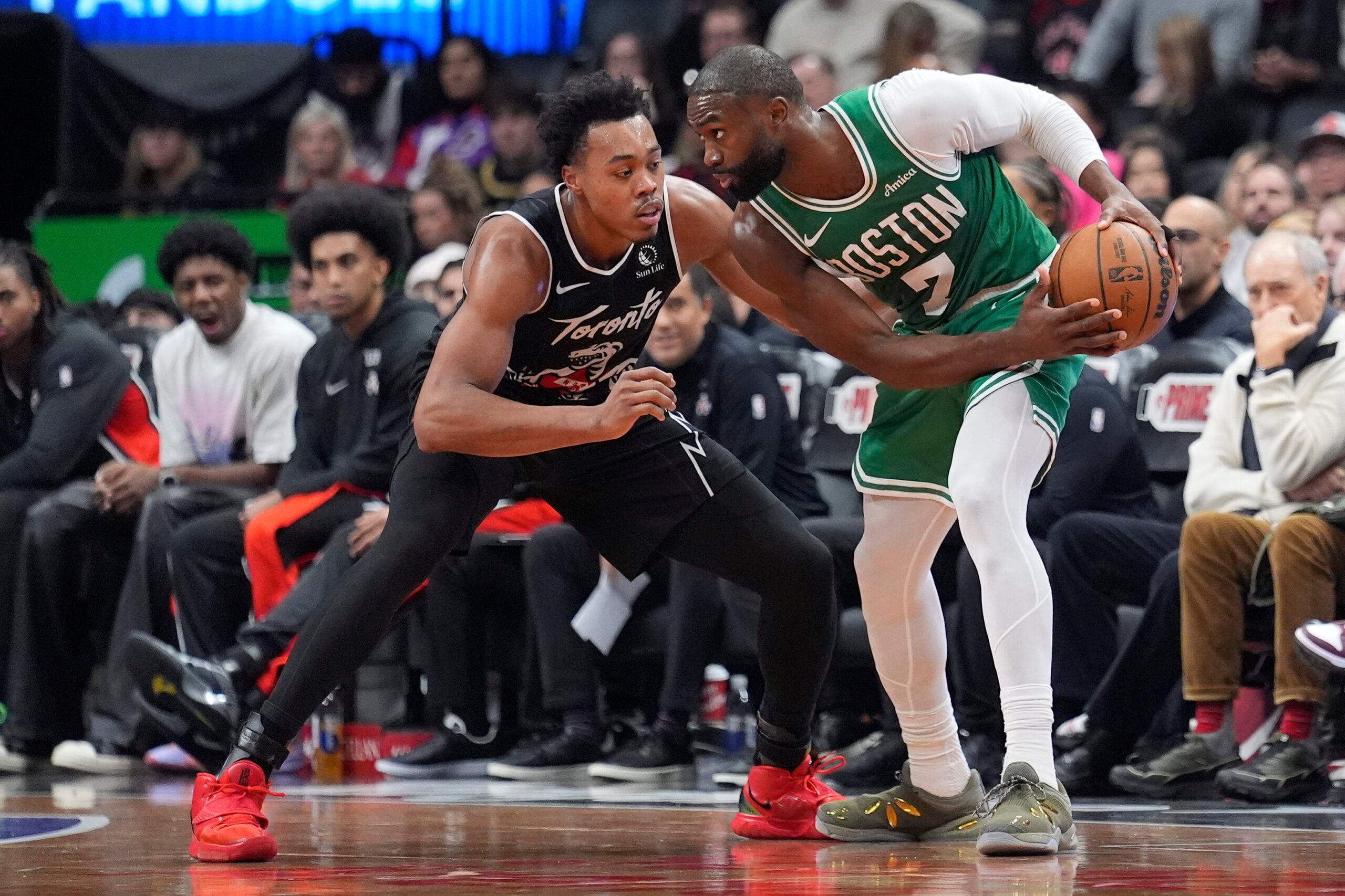 Dec 7, 2025; Toronto, Ontario, CAN; Boston Celtics forward Jaylen Brown (7) controls the ball against Toronto Raptors guard Scottie Barnes (4) during the second half at Scotiabank Arena. Mandatory Credit: John E. Sokolowski-Imagn Images