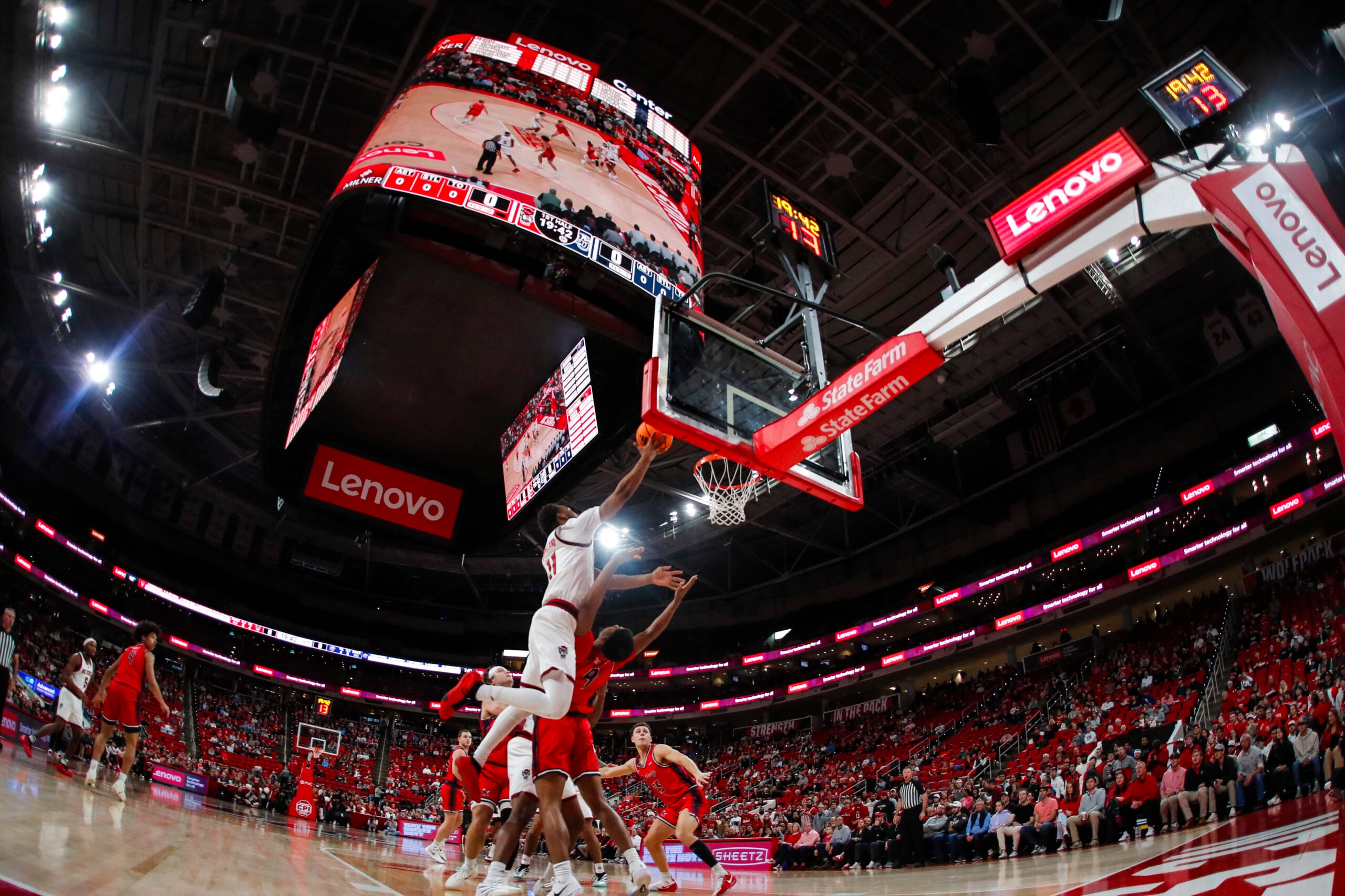 Dec 6, 2025; Raleigh, North Carolina, USA; NC State Wolfpack guard Quadir Copeland (11) dunks the ball past Liberty Flames guard JJ Harper (9) during the first half of the game at Lenovo Center. Mandatory Credit: Jaylynn Nash-Imagn Images