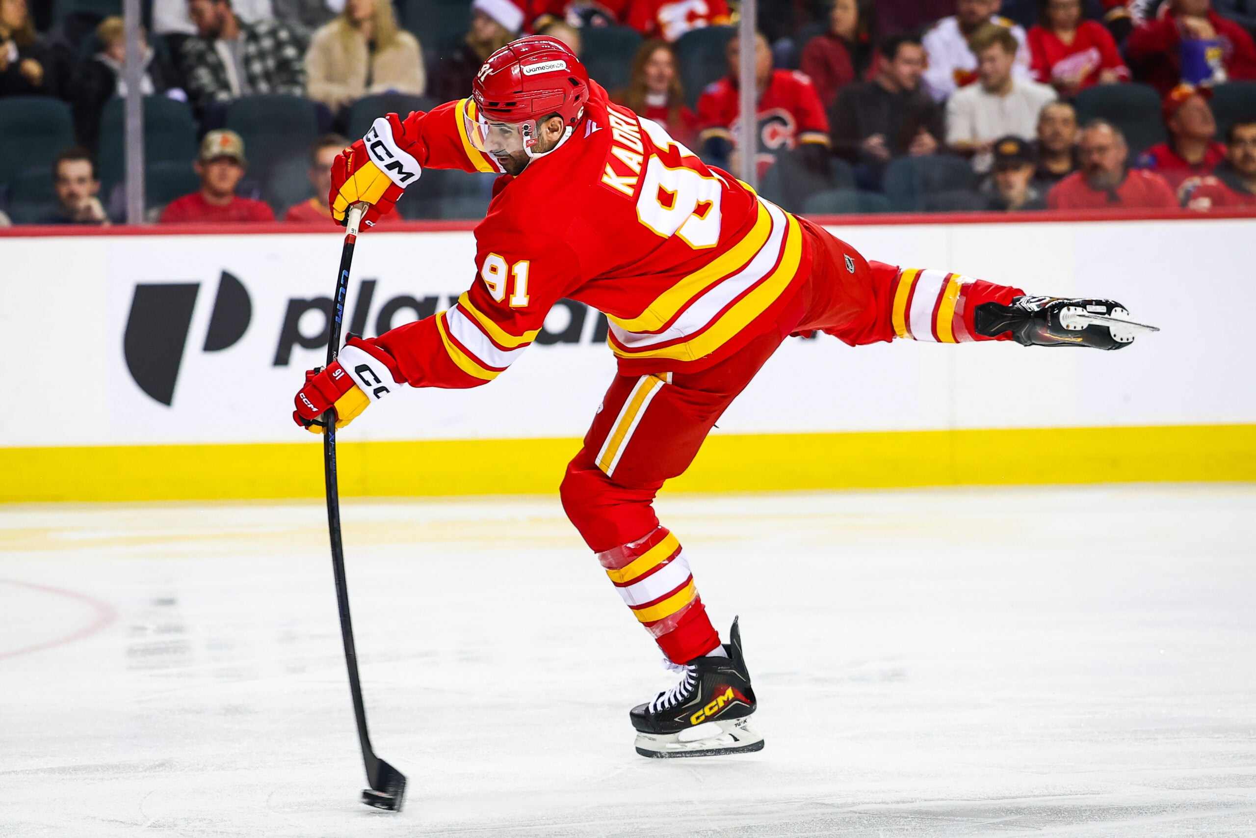 Dec 10, 2025; Calgary, Alberta, CAN; Calgary Flames center Nazem Kadri (91) shoots the puck against the Detroit Red Wings during the second period at Scotiabank Saddledome. Mandatory Credit: Sergei Belski-Imagn Images
