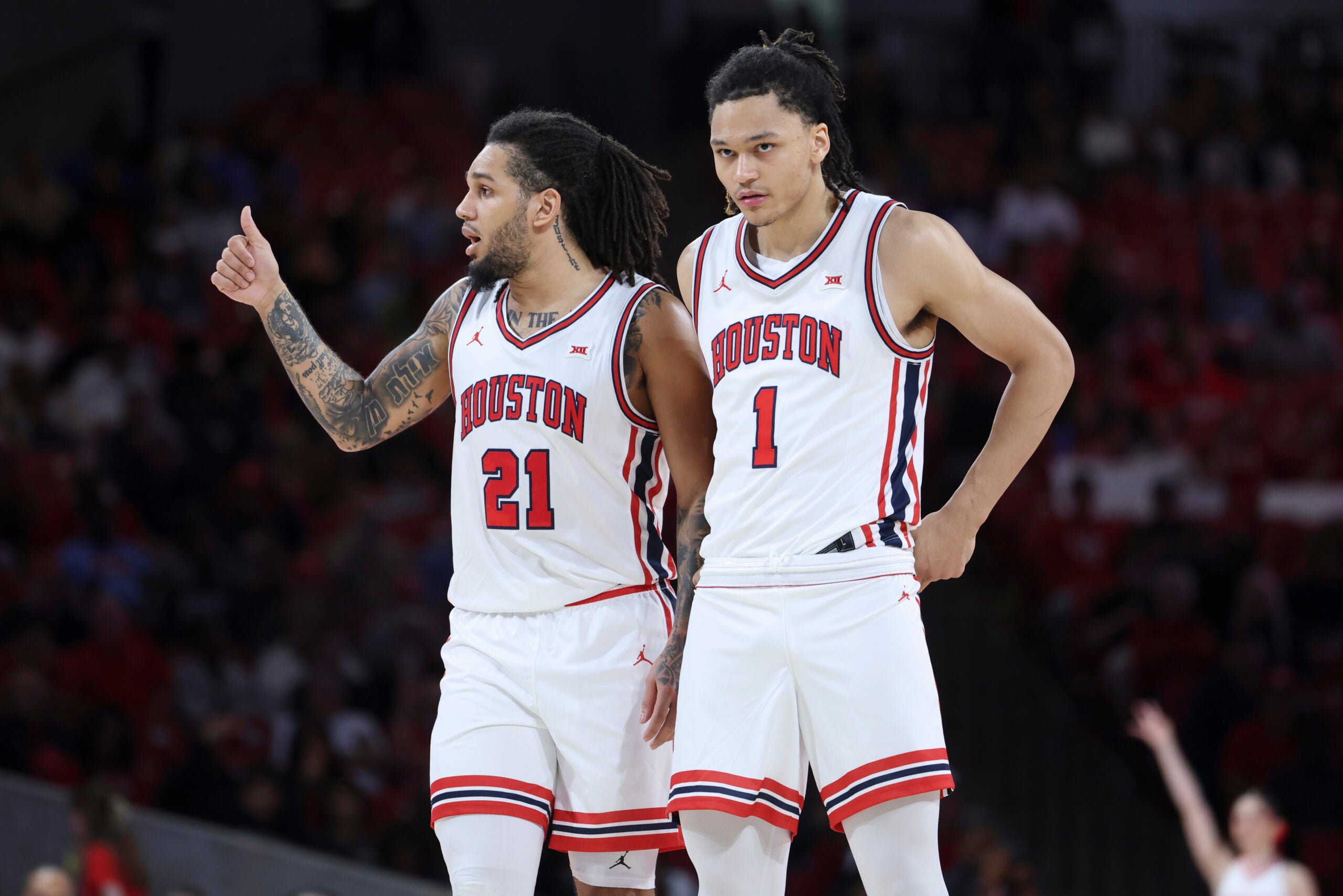 Dec 10, 2025; Houston, Texas, USA; Houston Cougars guard Isiah Harwell (1) looks on as guard Emanuel Sharp (21) gives a thumbs up during the second half against the Jackson State Tigers at Fertitta Center. Mandatory Credit: Troy Taormina-Imagn Images