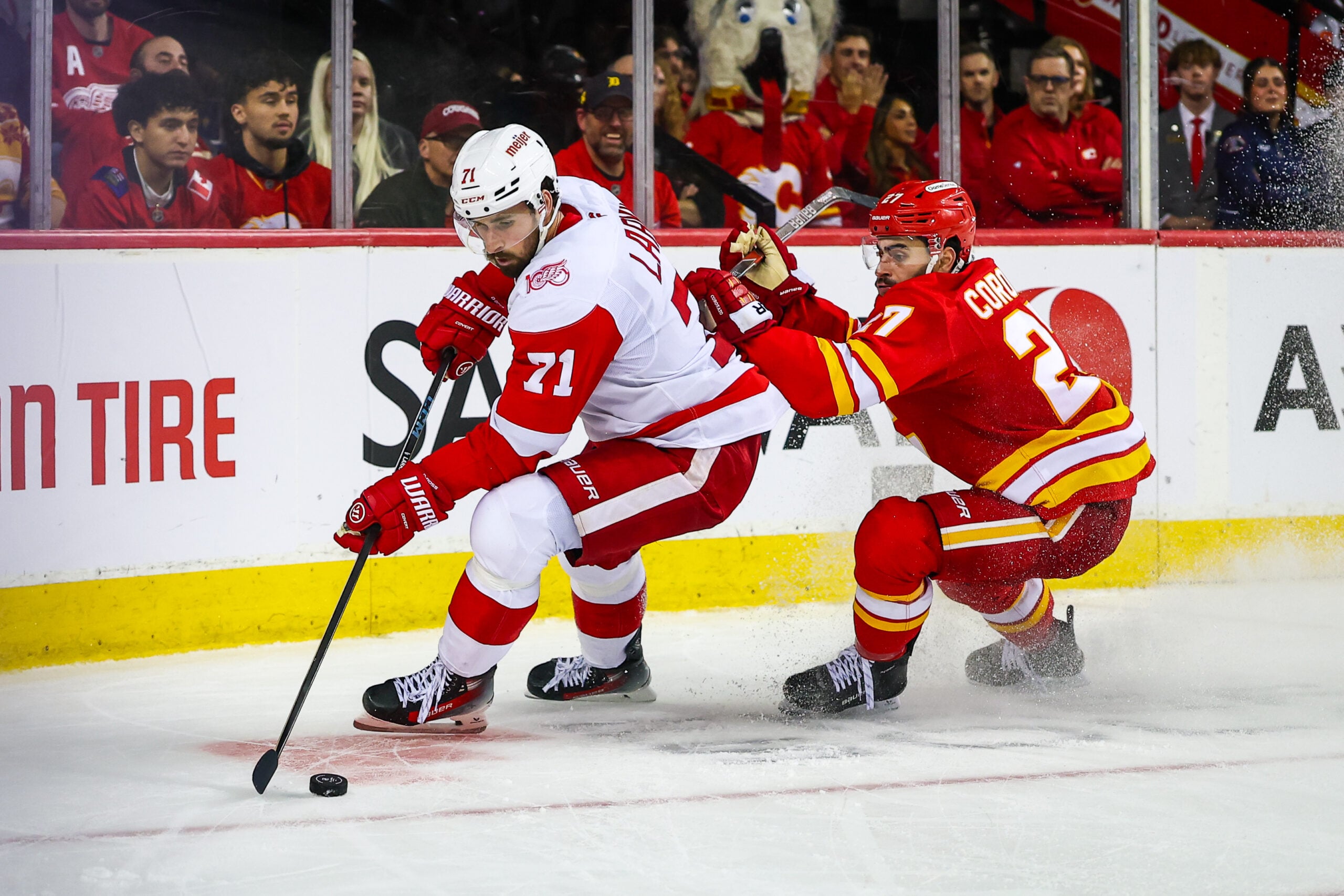 Dec 10, 2025; Calgary, Alberta, CAN; Detroit Red Wings center Dylan Larkin (71) and Calgary Flames right wing Matt Coronato (27) battle for the puck during the third period at Scotiabank Saddledome. Mandatory Credit: Sergei Belski-Imagn Images