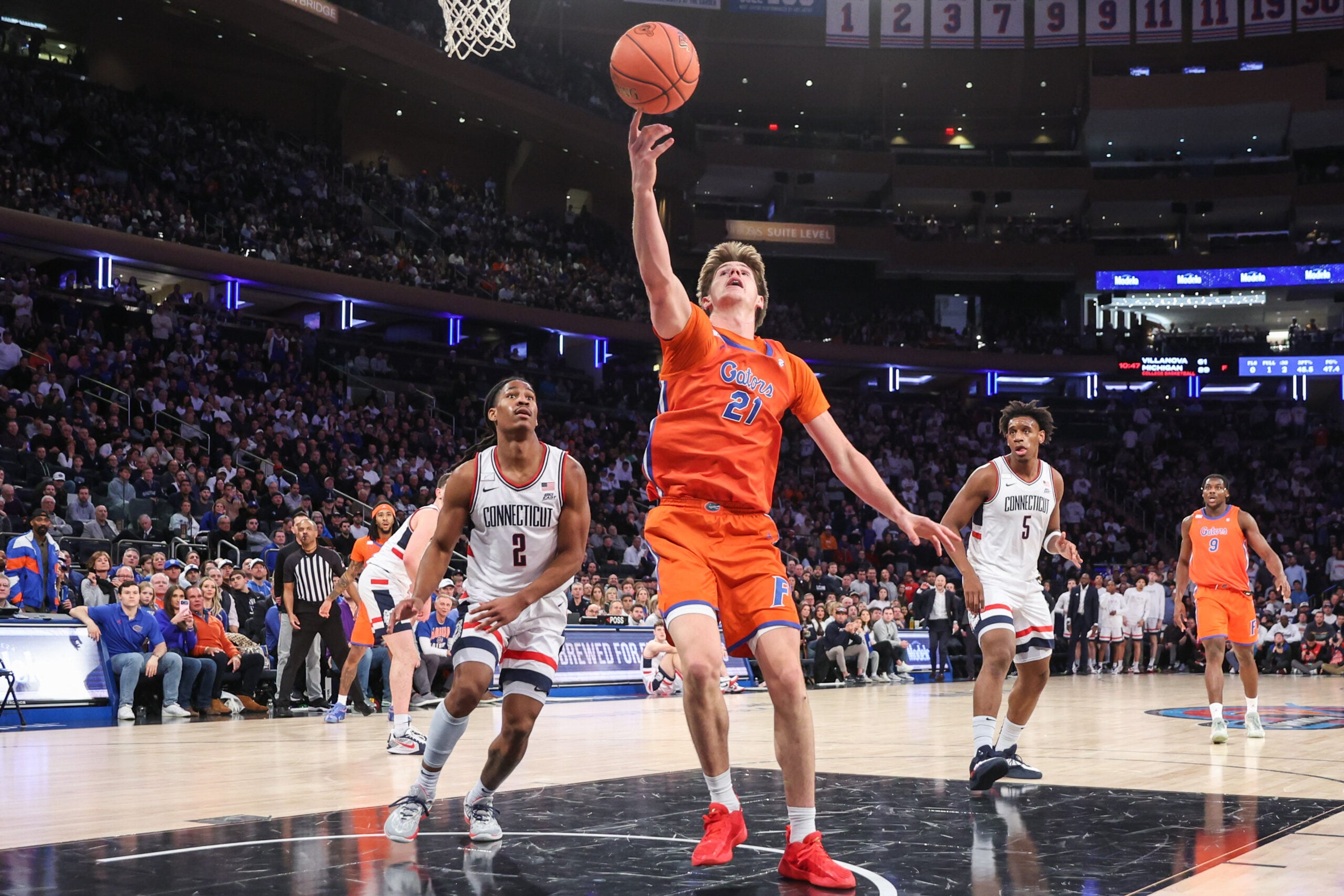 Dec 9, 2025; New York, New York, USA;  Florida Gators forward Alex Condon (21) and UConn Huskies guard Silas Demary Jr. (2) at Madison Square Garden. Mandatory Credit: Wendell Cruz-Imagn Images