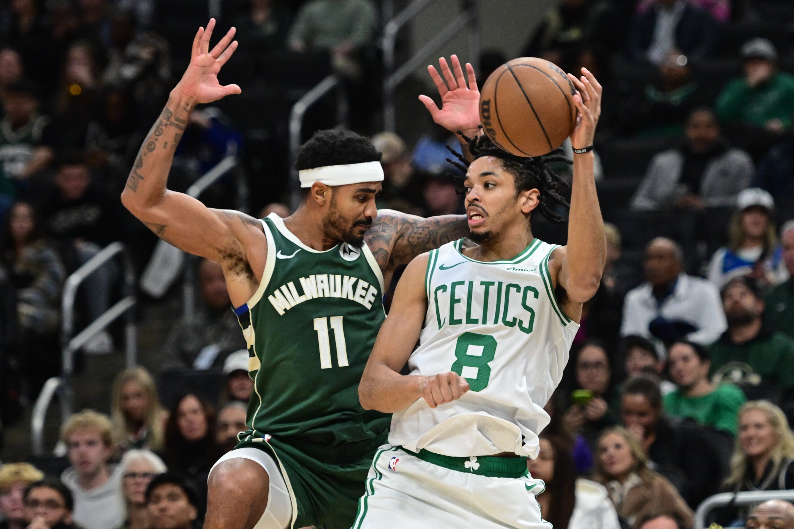 Dec 11, 2025; Milwaukee, Wisconsin, USA; Boston Celtics forward Josh Minott (8) passes the ball away from Milwaukee Bucks guard Gary Harris (11) in the third quarter at Fiserv Forum. Mandatory Credit: Benny Sieu-Imagn Images