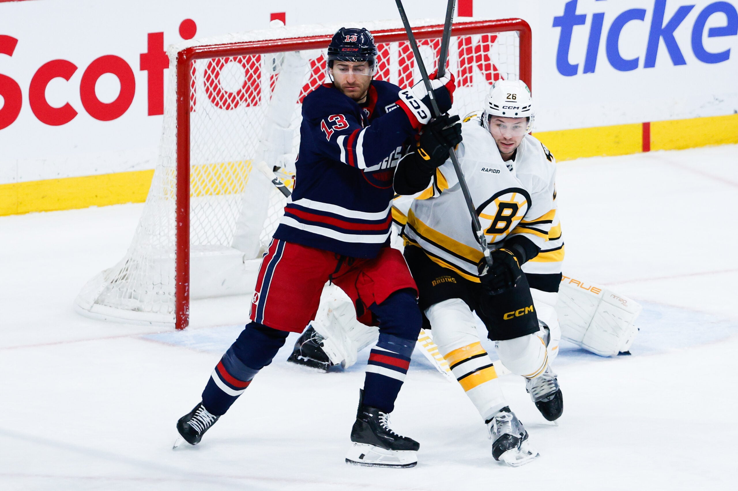 Dec 11, 2025; Winnipeg, Manitoba, CAN; Winnipeg Jets forward Gabriel Vilardi (13) jostles for position with Boston Bruins defensema Andrew Peeke (26) during the third period at Canada Life Centre. Mandatory Credit: Terrence Lee-Imagn Images