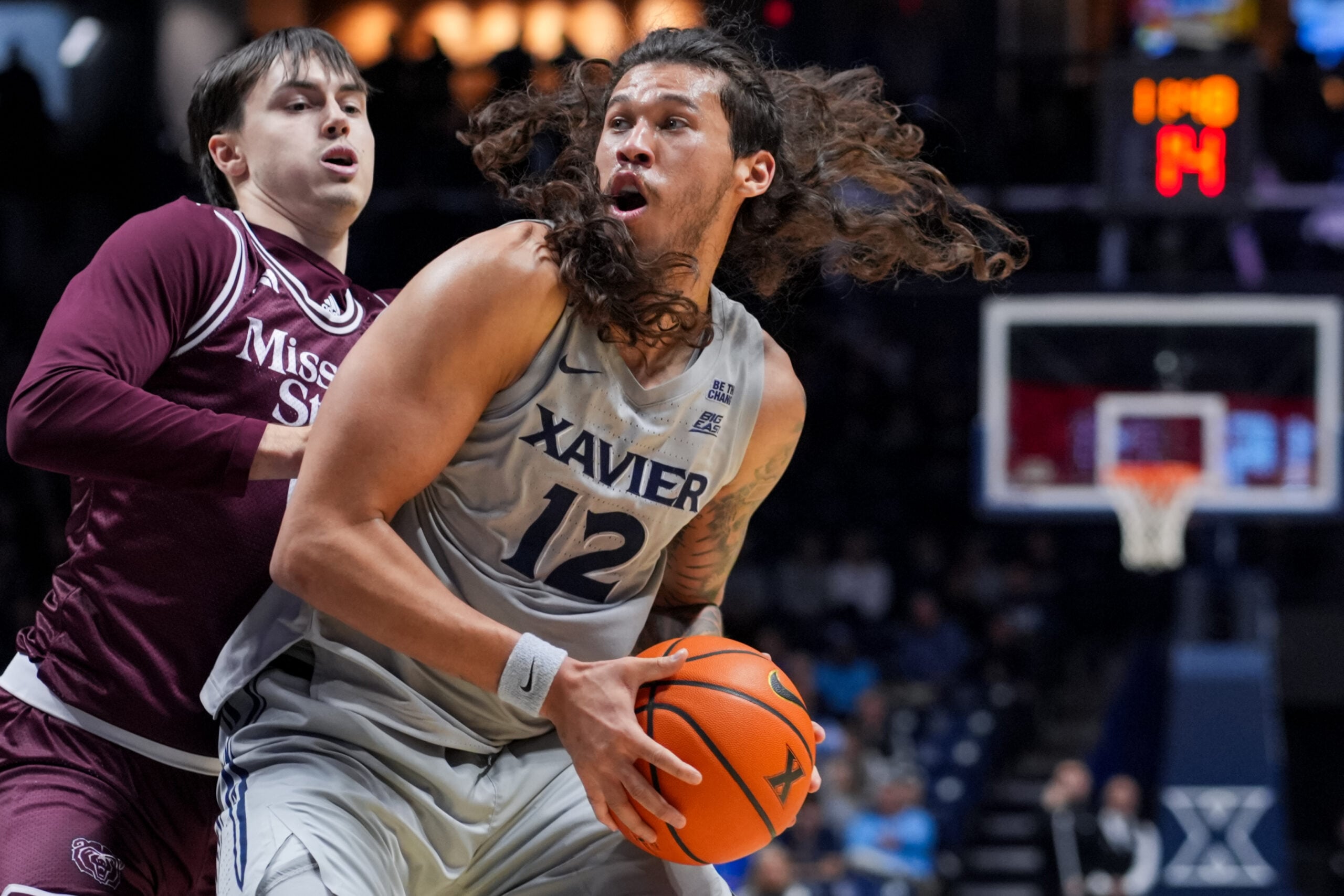 Dec 12, 2025; Cincinnati, Ohio, USA;  Xavier Musketeers forward Tre Carroll (12) dribbles the ball against Missouri State Bears guard Logan Epes (6) in the first half at the Cintas Center. Mandatory Credit: Aaron Doster-Imagn Images