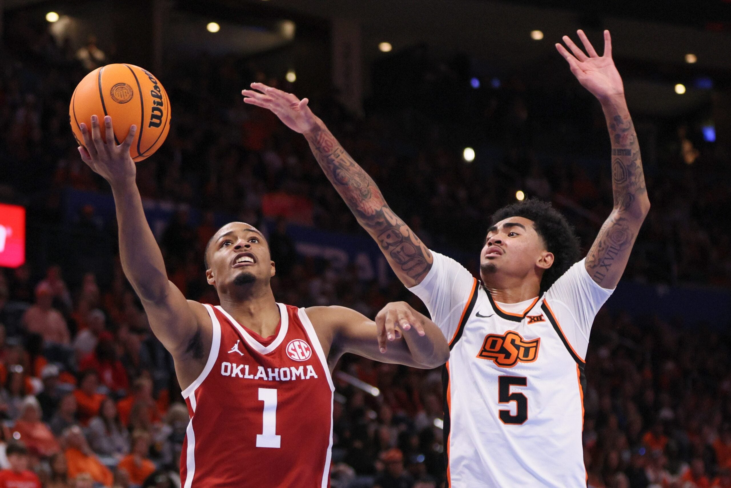 Oklahoma guard Xzayvier Brown (1) looks to shoot next to Oklahoma State guard Vyctorius Miller (5) during the second half of a Bedlam men's college basketball game between the OSU Cowboys and OU Sooners at Paycom Center in Oklahoma City, Saturday, Dec. 13, 2025.