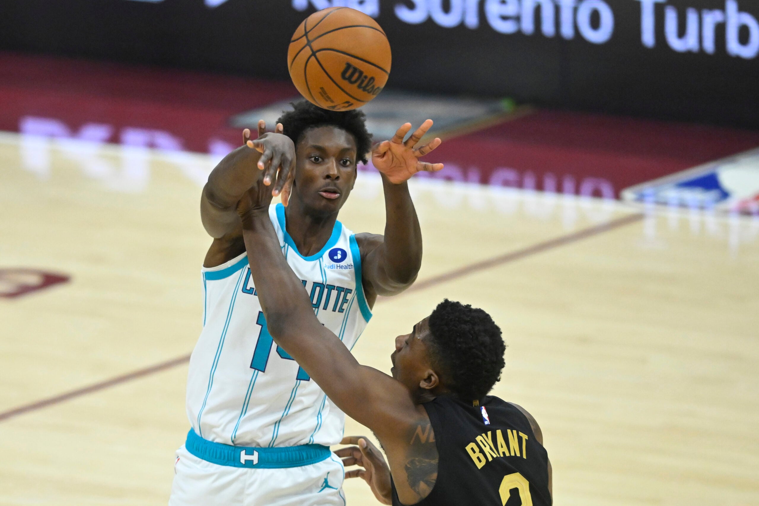 Dec 14, 2025; Cleveland, Ohio, USA; Charlotte Hornets forward Moussa Diabate (14) passes the ball beside Cleveland Cavaliers center Thomas Bryant (3) in the third quarter at Rocket Arena. Mandatory Credit: David Richard-Imagn Images