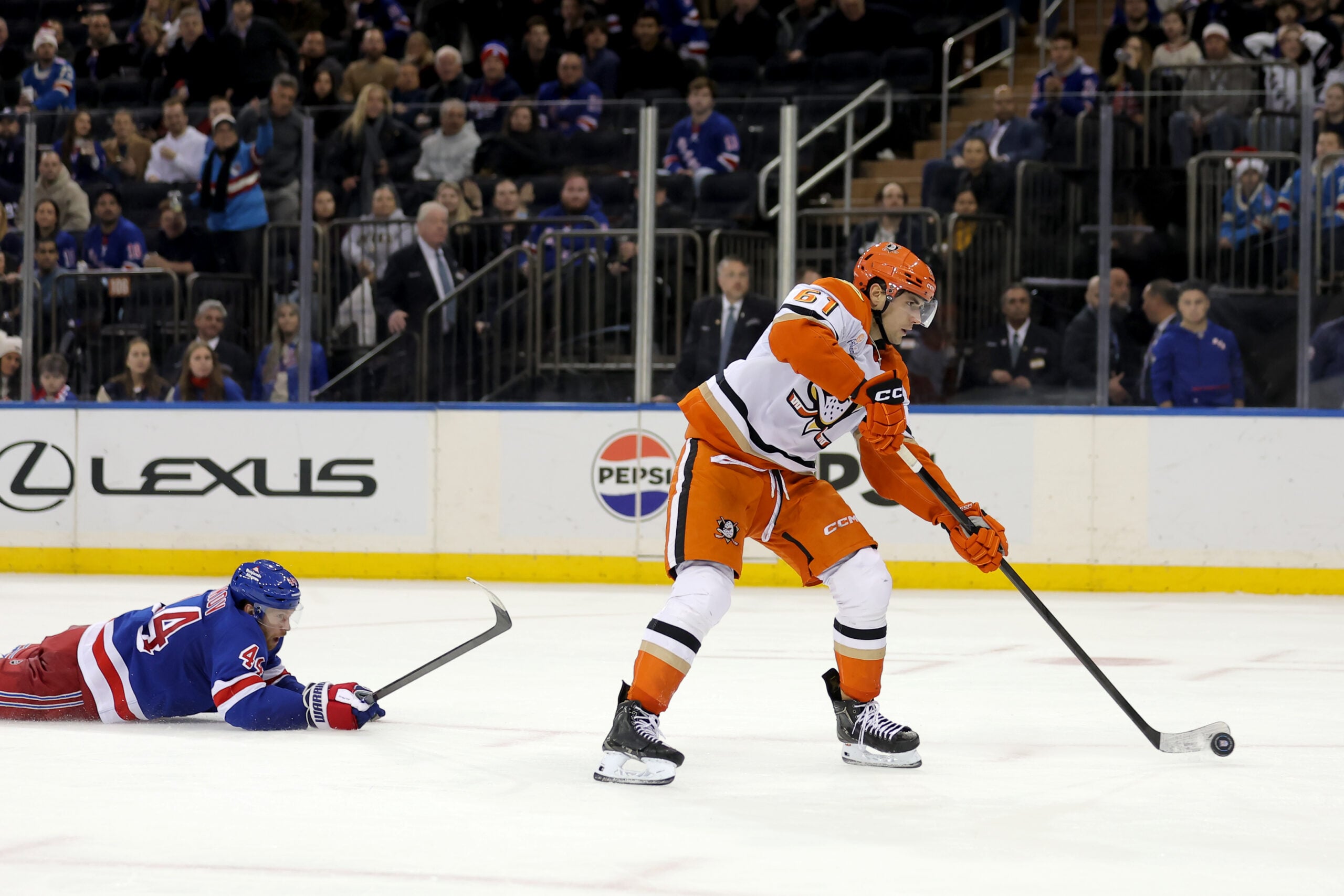 Dec 15, 2025; New York, New York, USA; Anaheim Ducks left wing Cutter Gauthier (61) scores an empty net goal against New York Rangers defenseman Vladislav Gavrikov (44) during the third period at Madison Square Garden. Mandatory Credit: Brad Penner-Imagn Images