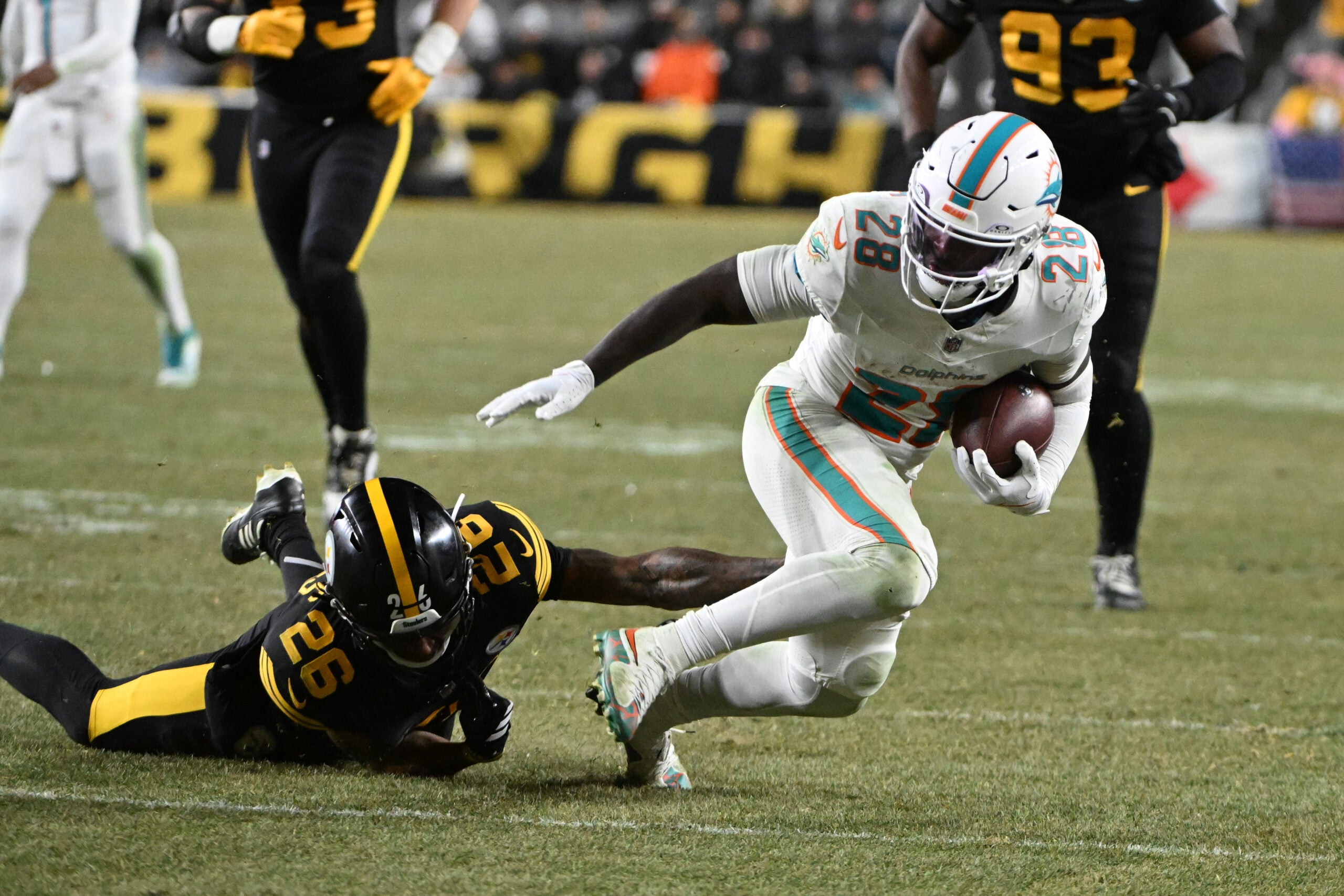 Dec 15, 2025; Pittsburgh, Pennsylvania, USA; Miami Dolphins running back De'Von Achane (28) escapes a tackle by Pittsburgh Steelers cornerback Brandin Echols (26) in the fourth quarter at Acrisure Stadium. Mandatory Credit: Barry Reeger-Imagn Images