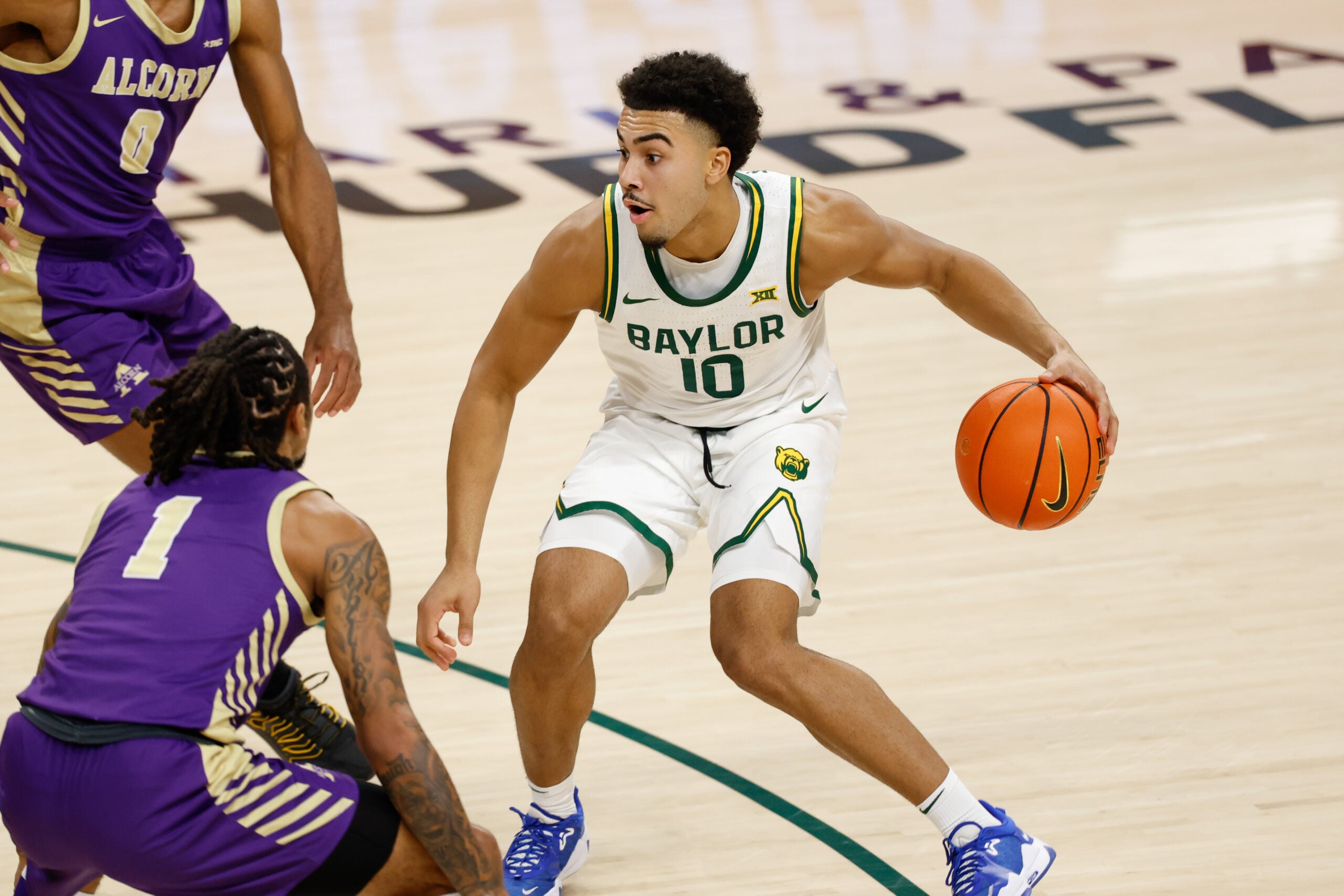 Dec 19, 2025; Waco, Texas, USA;  Baylor Bears guard Isaac Williams (10) dribbles between Alcorn State Braves guard Shane Lancaster (0) and guard Jameel Morris (1) during the second half at Paul and Alejandra Foster Pavilion. Mandatory Credit: Chris Jones-Imagn Images