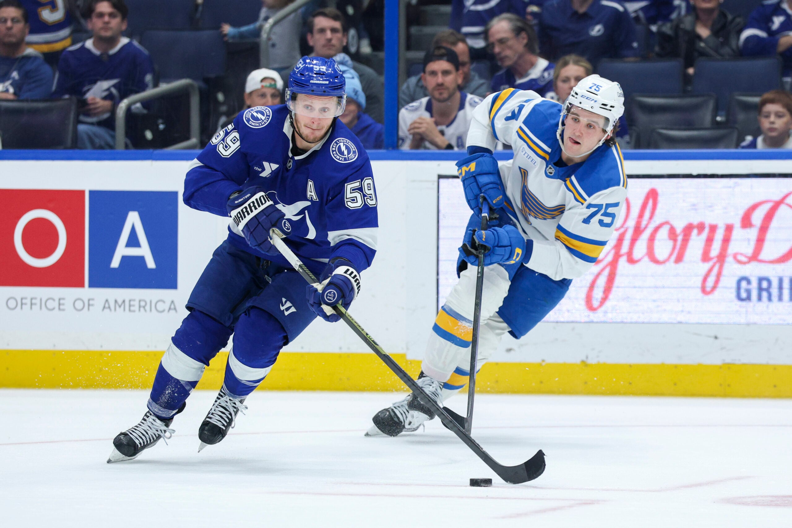 Dec 22, 2025; Tampa, Florida, USA; Tampa Bay Lightning center Jake Guentzel (59) controls the puck from St. Louis Blues defenseman Tyler Tucker (75) in the third period at Benchmark International Arena. Mandatory Credit: Nathan Ray Seebeck-Imagn Images