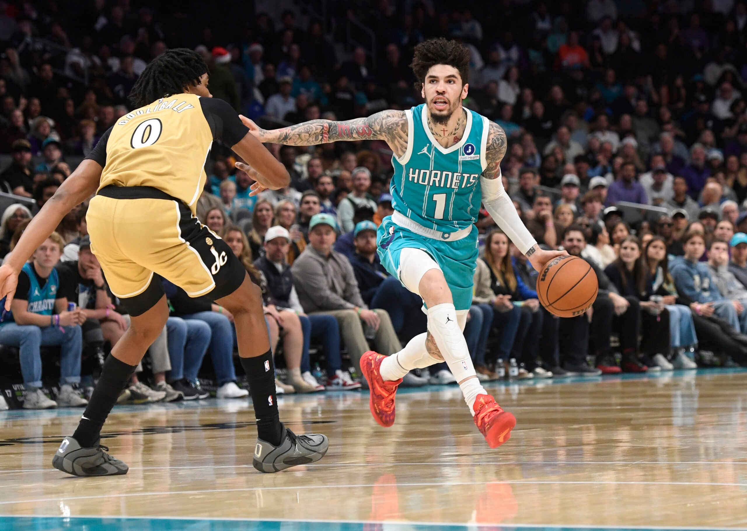 Dec 23, 2025; Charlotte, North Carolina, USA;  Charlotte Hornets guard LaMelo Ball (1) drives past Washington Wizards forward Bilal Coulibaly (0) during the second half at the Spectrum Center. Mandatory Credit: Sam Sharpe-Imagn Images