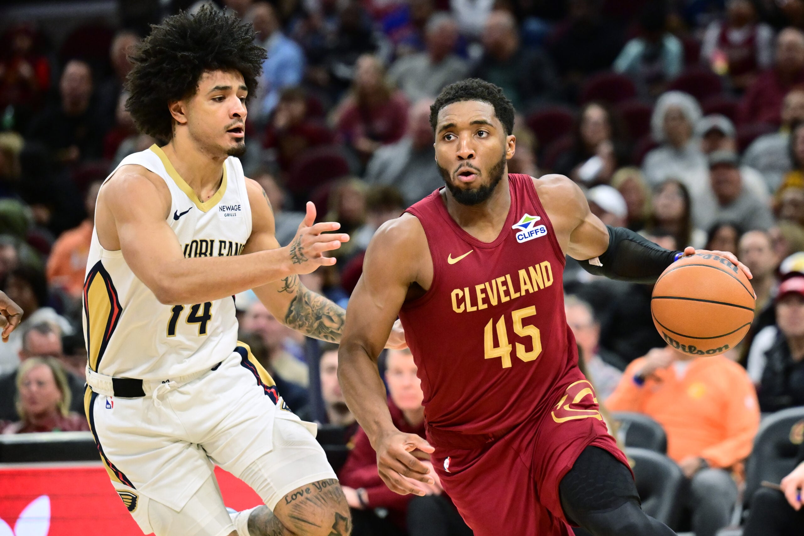 Dec 23, 2025; Cleveland, Ohio, USA; Cleveland Cavaliers guard Donovan Mitchell (45) drives to the basket against New Orleans Pelicans guard Micah Peavy (14) during the second half at Rocket Arena. Mandatory Credit: Ken Blaze-Imagn Images