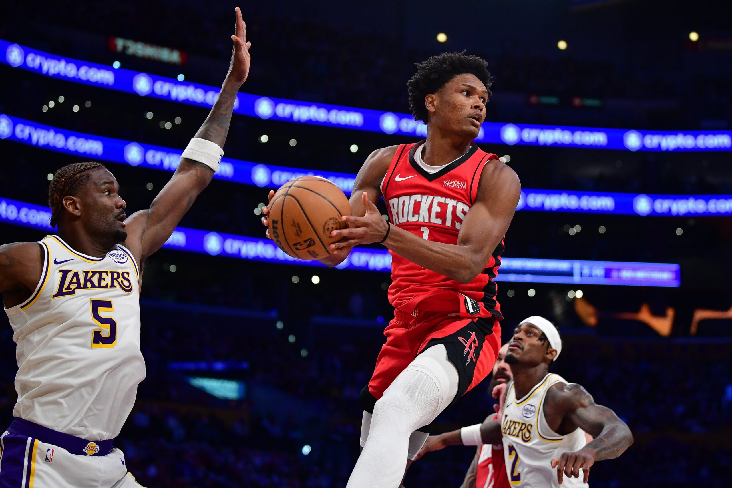 Dec 25, 2025; Los Angeles, California, USA; Houston Rockets guard Amen Thompson (1) passes the ball against the defense of Los Angeles Lakers center Deandre Ayton (5) during the second half at Crypto.com Arena. Mandatory Credit: Gary A. Vasquez-Imagn Images