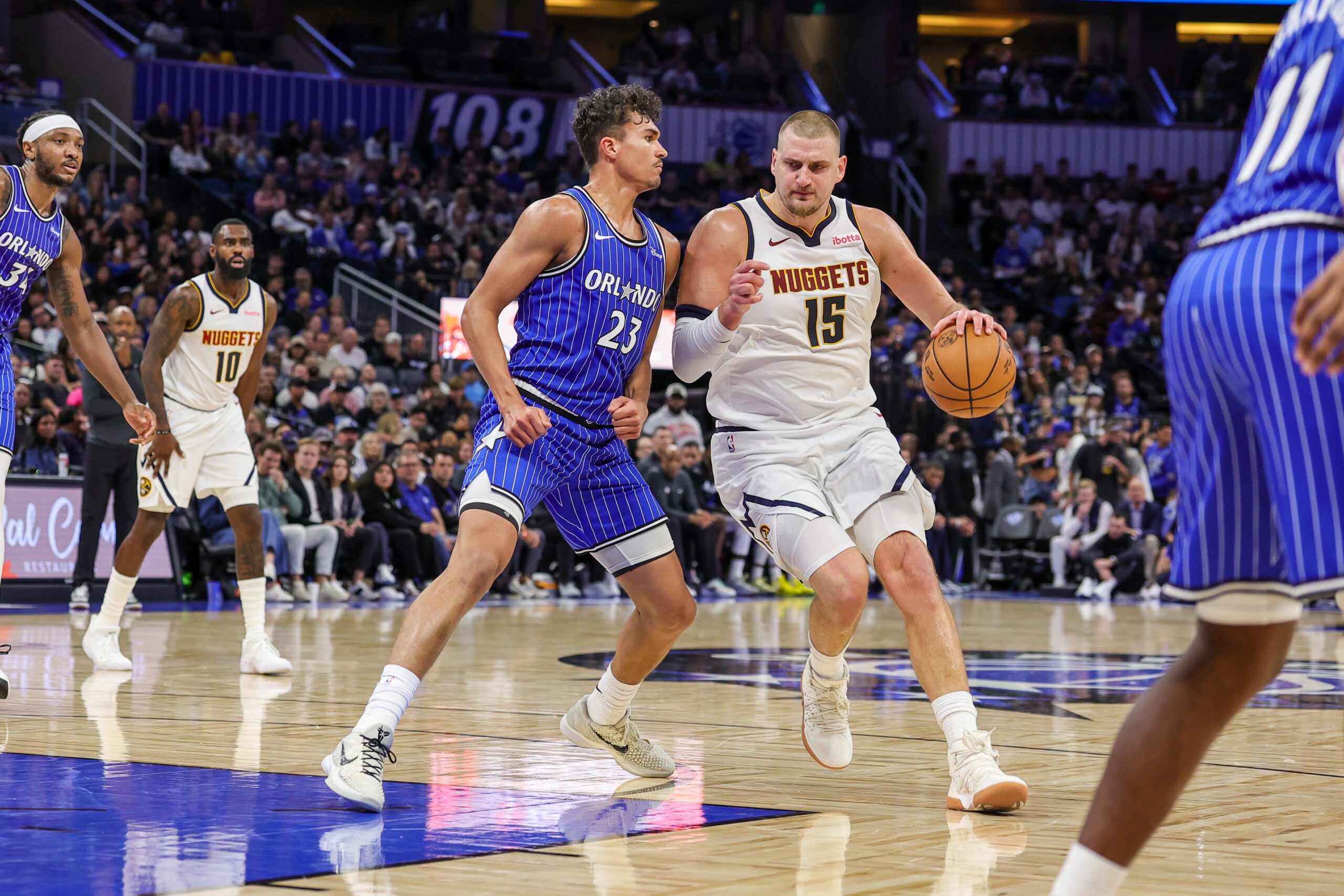 Dec 27, 2025; Orlando, Florida, USA; Denver Nuggets center Nikola Jokic (15) drives around Orlando Magic forward Tristan da Silva (23) during the second half at Kia Center. Mandatory Credit: Mike Watters-Imagn Images