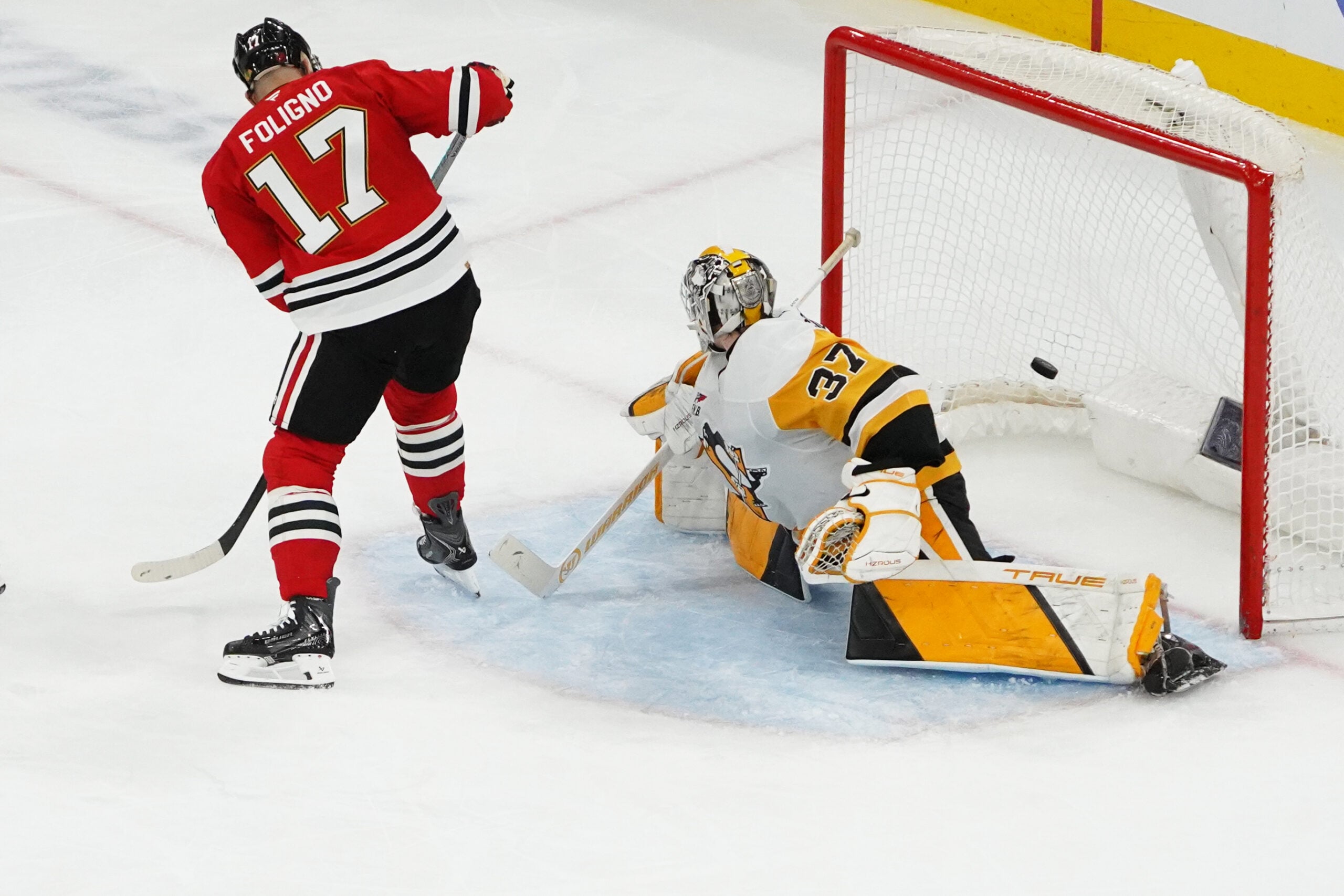 Dec 28, 2025; Chicago, Illinois, USA; Chicago Blackhawks left wing Nick Foligno (17) scores a goal with a backward shot through his legs on Pittsburgh Penguins goaltender Arturs Silovs (37) during the second period at United Center. Mandatory Credit: David Banks-Imagn Images