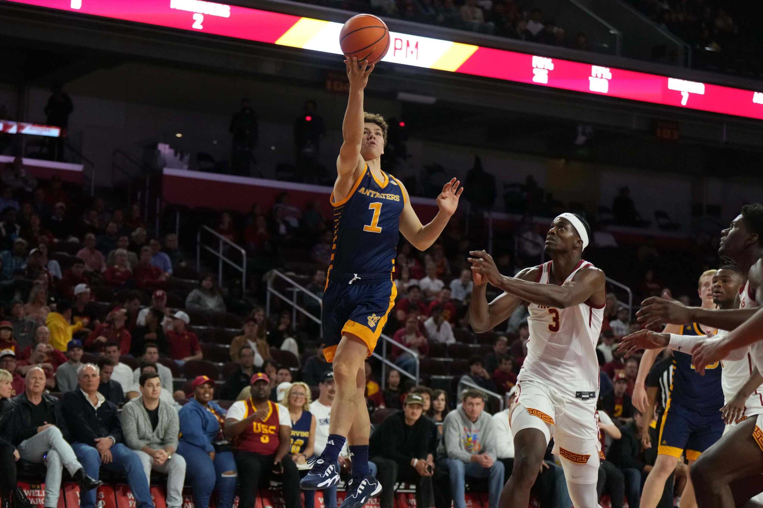 Nov 14, 2023; Los Angeles, California, USA; UC Irvine Anteaters guard Derin Saran (1) shoots the ball against Southern California Trojans forward Vincent Iwuchukwu (3) in the first half at Galen Center. Mandatory Credit: Kirby Lee-Imagn Images