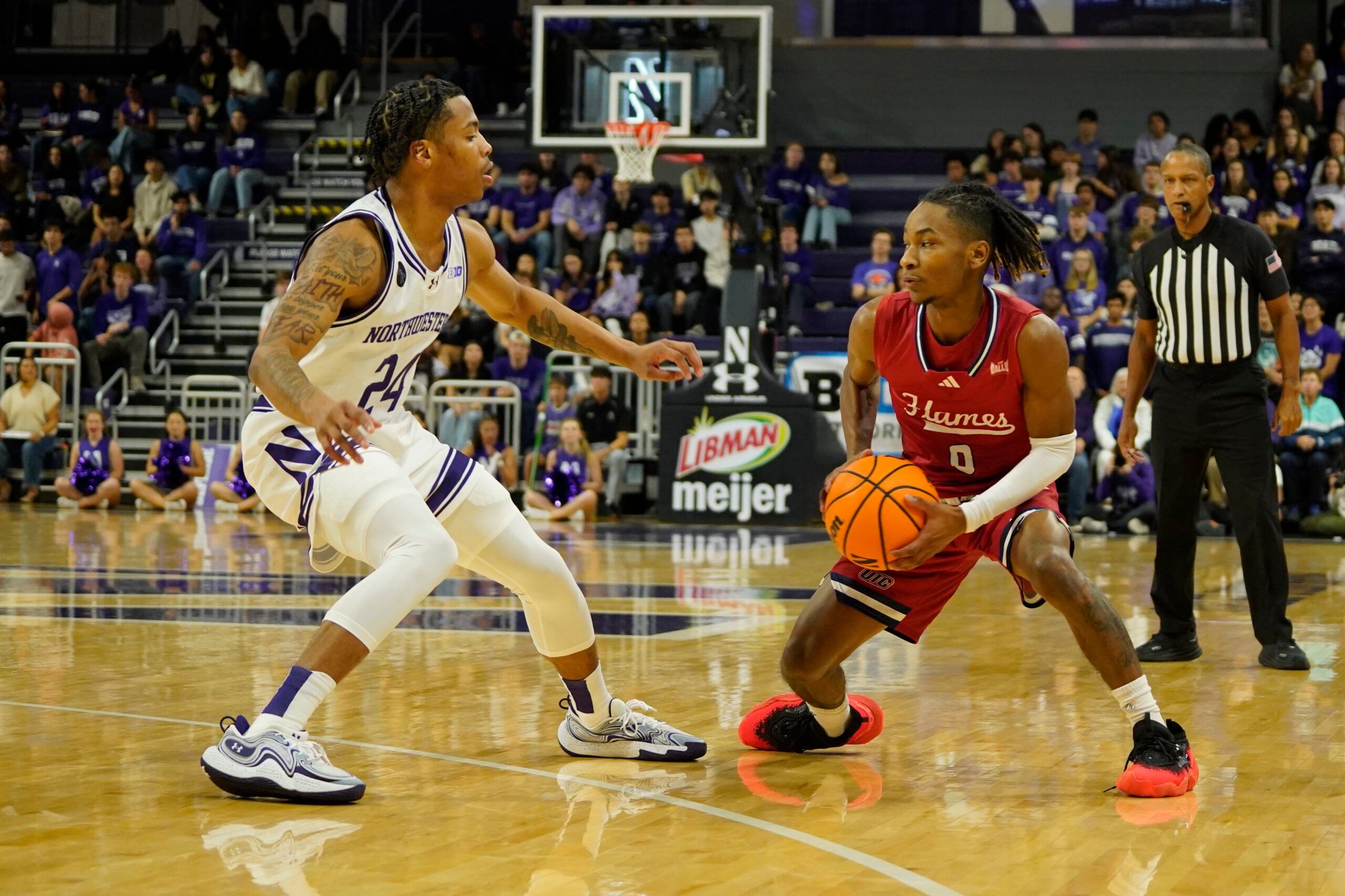 Nov 12, 2024; Evanston, Illinois, USA; Northwestern Wildcats guard K.J. Windham (24) defends Illinois-Chicago Flames guard Ahmad Henderson II (0) during the first half at Welsh-Ryan Arena. Mandatory Credit: David Banks-Imagn Images