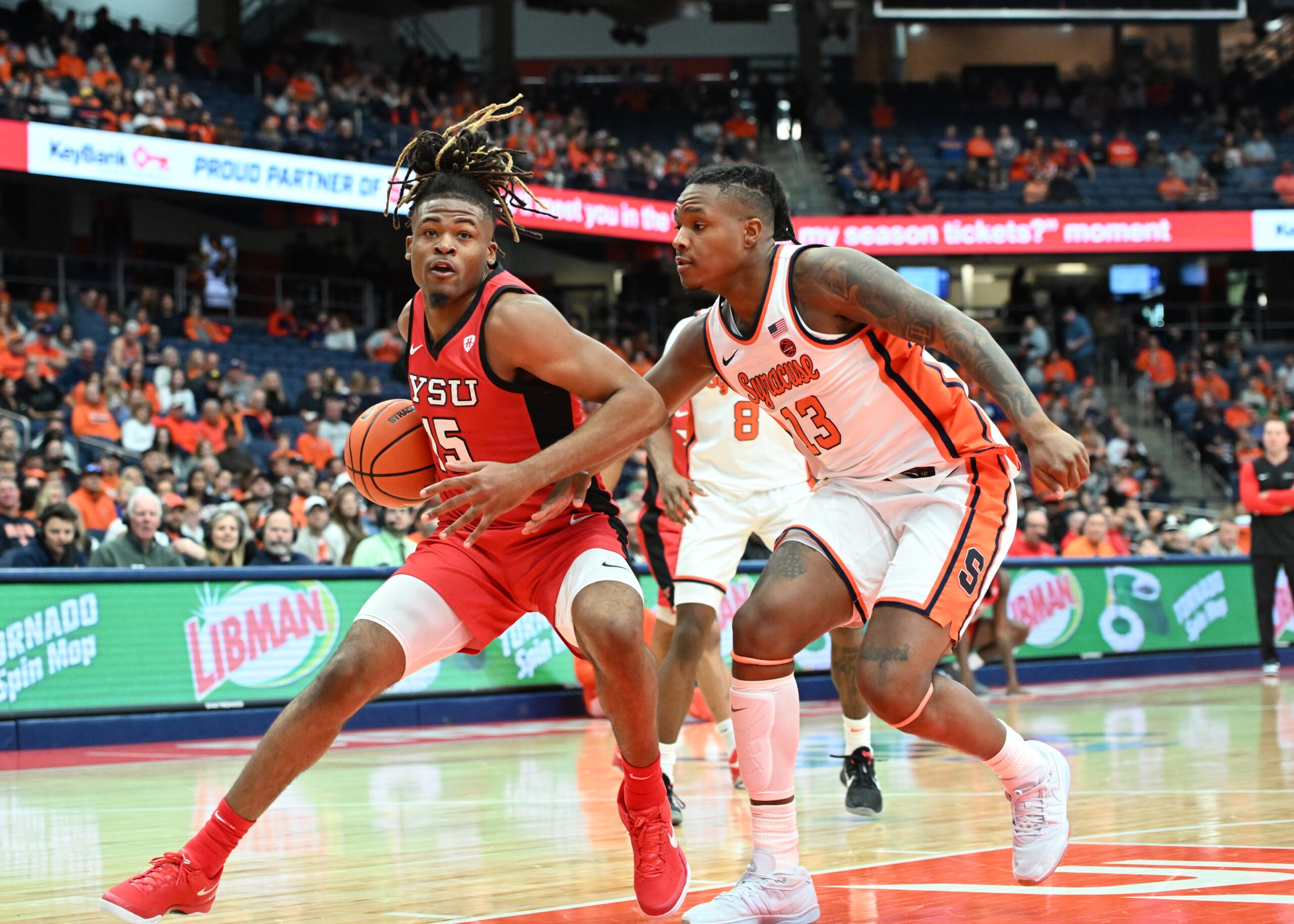Nov 16, 2024; Syracuse, New York, USA; Youngstown State Penguins forward Cris Carroll (15) looks to the basket with Syracuse Orange forward Jyare Davis (13) defending in the first half at the JMA Wireless Dome. Mandatory Credit: Mark Konezny-Imagn Images