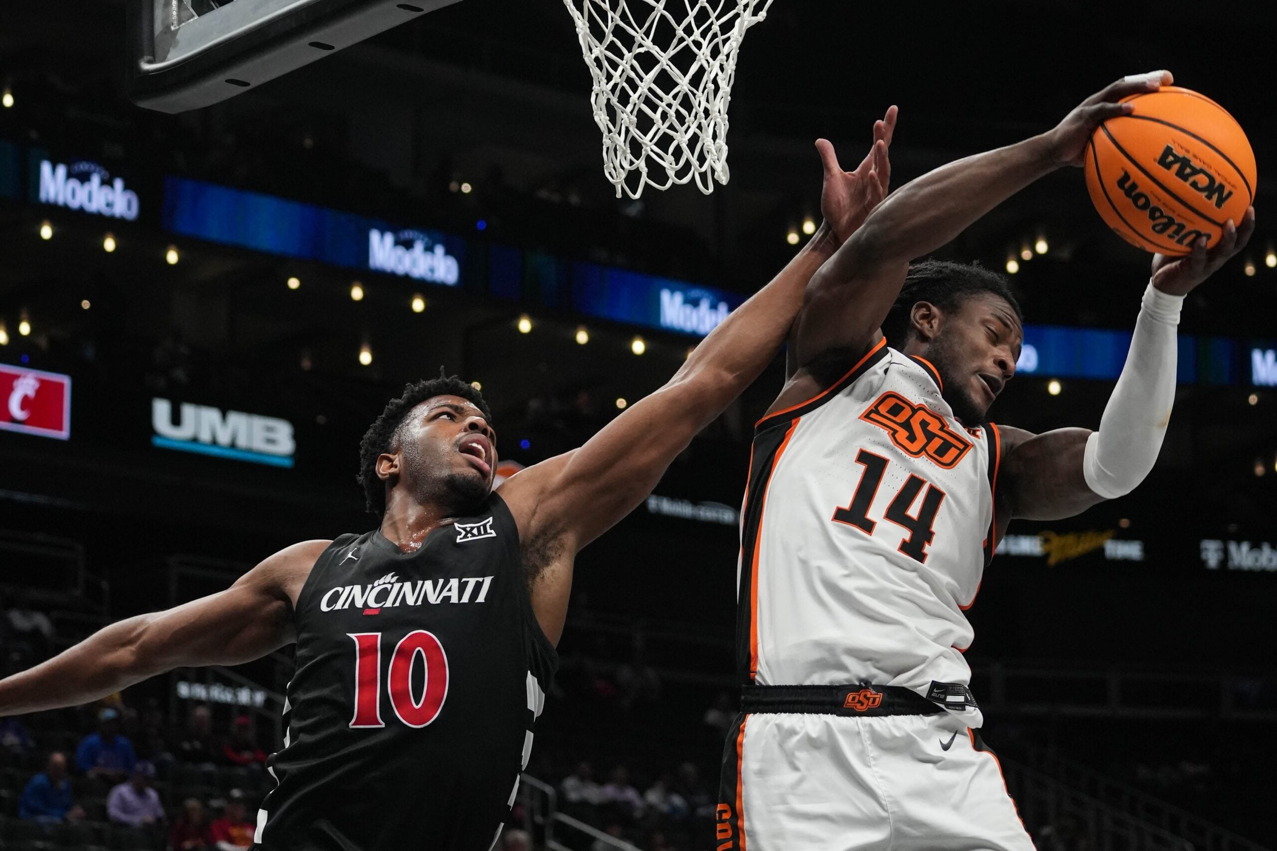 Cowboys Jamyron Keller (14) recovers the ball before Bearcats Josh Reed (10) during Game 1 of the 2025 Phillips 66 Big 12 Basketball Championship against the Oklahoma State Cowboys at the T-Mobile Center in Kansas City, Missouri on Tuesday March 11, 2025. Bearcats won the game with a final score of 87-68.