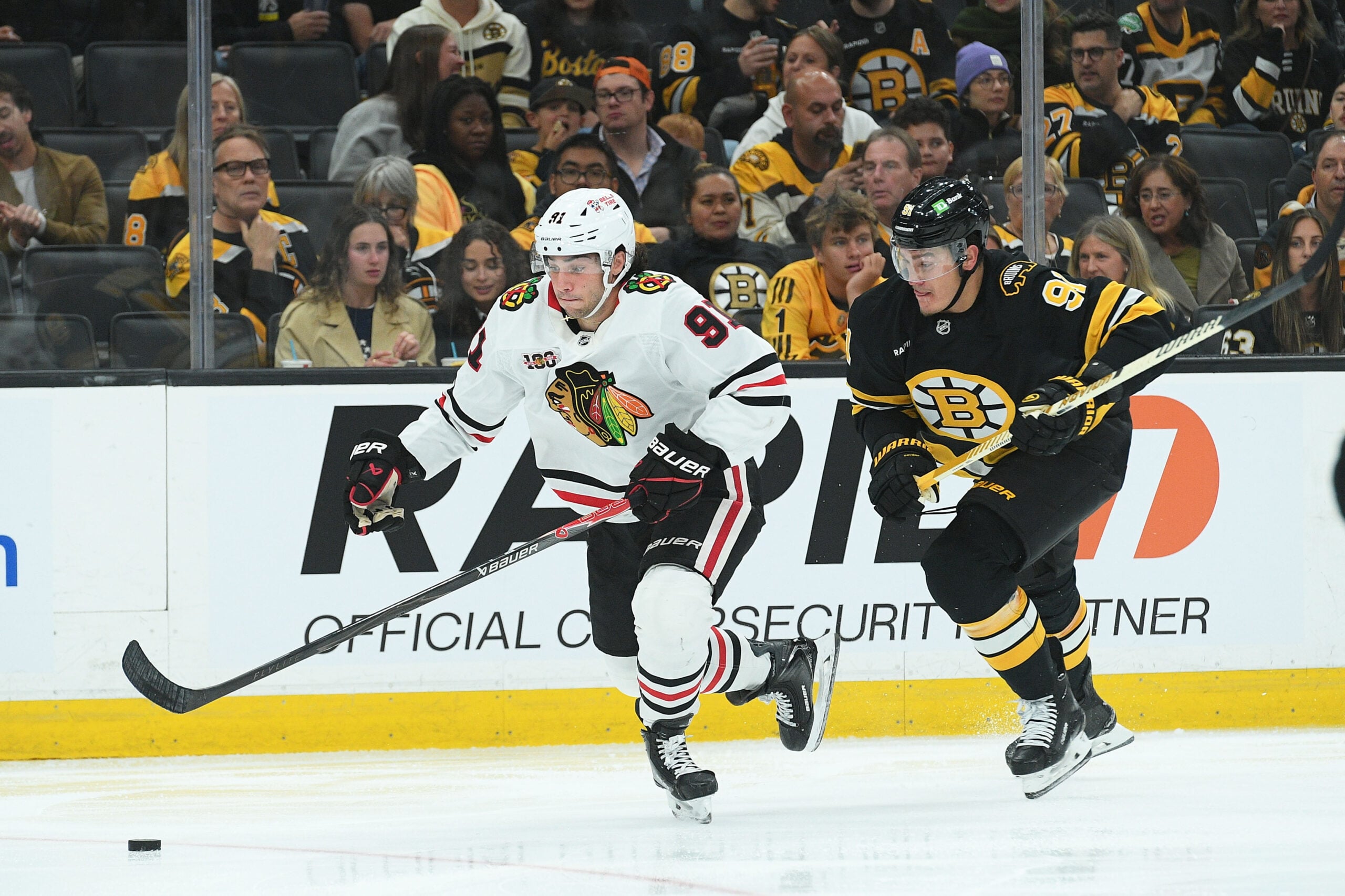 Oct 9, 2025; Boston, Massachusetts, USA; Chicago Blackhawks center Frank Nazar (91) controls the puck ahead of Boston Bruins defenseman Nikita Zadorov (91) during the second period at TD Garden. Mandatory Credit: Bob DeChiara-Imagn Images