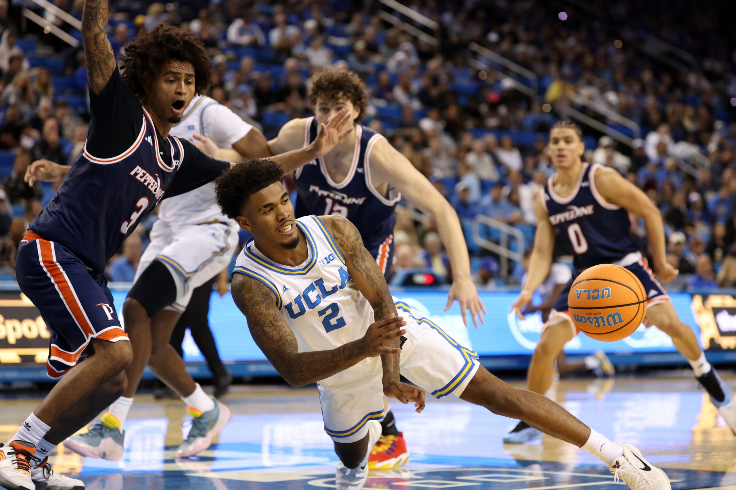 Nov 7, 2025; Los Angeles, California, USA; UCLA Bruins guard Donovan Dent (2) passes the ball during the first half against the Pepperdine Waves at Pauley Pavilion presented by Wescom Financial. Mandatory Credit: Kiyoshi Mio-Imagn Images