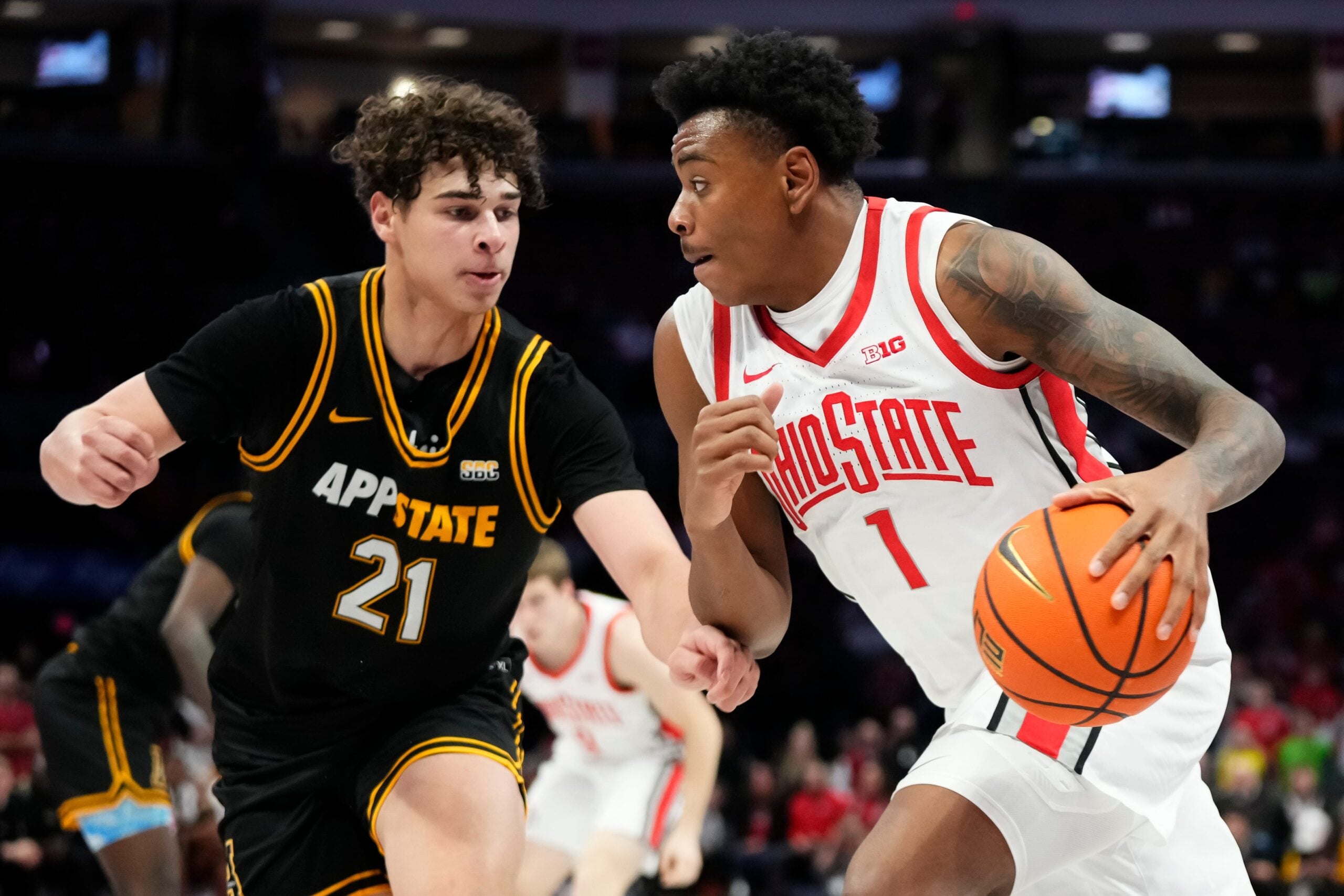 Ohio State Buckeyes forward Devin Royal (21) drives past Appalachian State Mountaineers forward Andrin Njock (21) during the NCAA men's basketball game at Value City Arena in Columbus on Nov. 11, 2025. Ohio State won 75-53.