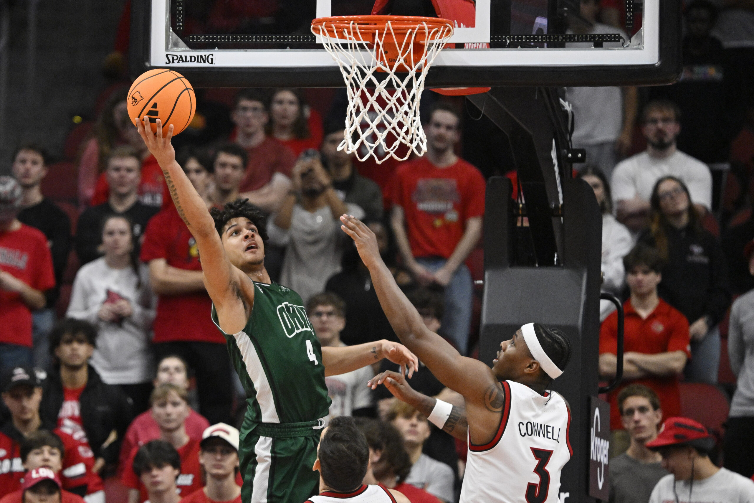Nov 15, 2025; Louisville, Kentucky, USA;  Ohio Bobcats guard JJ Kelly (4) shoots against Louisville Cardinals guard Ryan Conwell (3) during the second half at KFC Yum! Center. Louisville defeated Ohio 106-81. Mandatory Credit: Jamie Rhodes-Imagn Images
