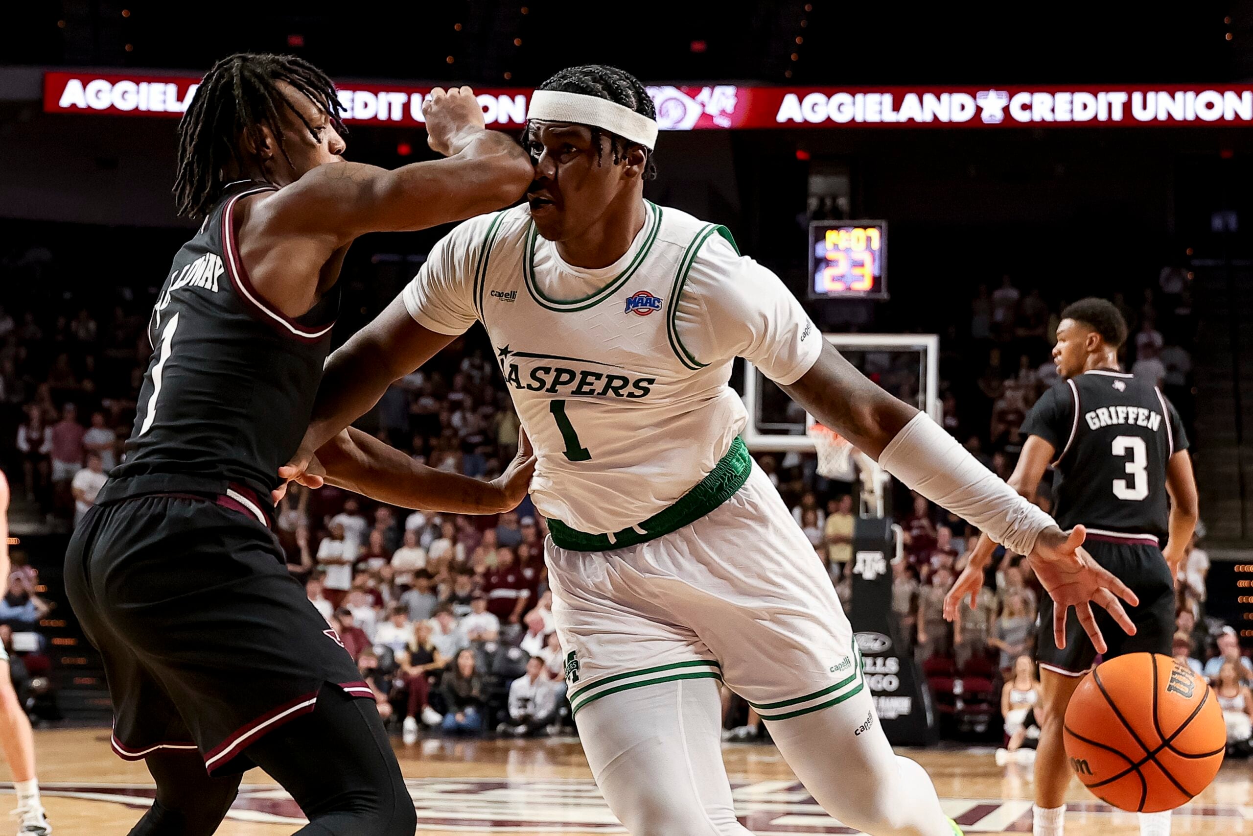Nov 21, 2025; College Station, Texas, USA; Manhattan Jaspers forward Anthony Isaac (1) dribbles the ball as Texas A&M Aggies guard Josh Holloway (1) defends during the second half at Reed Arena. Mandatory Credit: Maria Lysaker-Imagn Images
