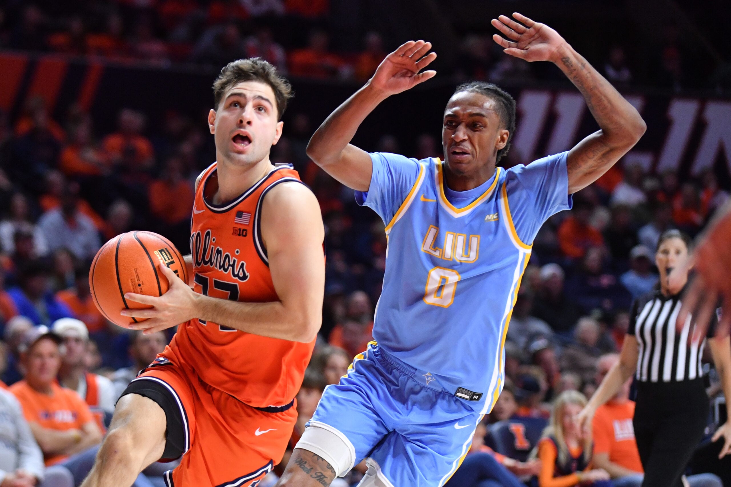 Nov 22, 2025; Champaign, Illinois, USA; Illinois Fighting Illini guard Mihailo Petrovic (77) drives past Long Island University Sharks guard Malachi Davis (0) during the first half at State Farm Center. Mandatory Credit: Ron Johnson-Imagn Images