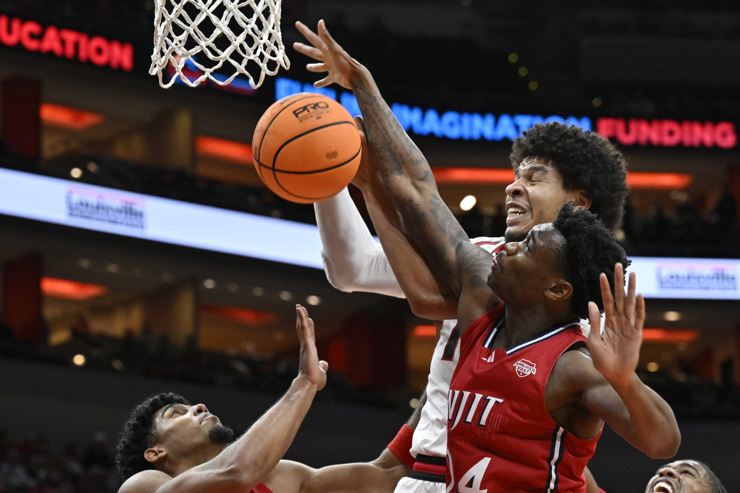 Nov 26, 2025; Louisville, Kentucky, USA; NJIT Highlanders guard Ari Fulton (24) battles Louisville Cardinals forward Sananda Fru (13) for a rebound during the second half at KFC Yum! Center. Louisville defeated New Jersey Tech 104-47. Mandatory Credit: Jamie Rhodes-Imagn Images