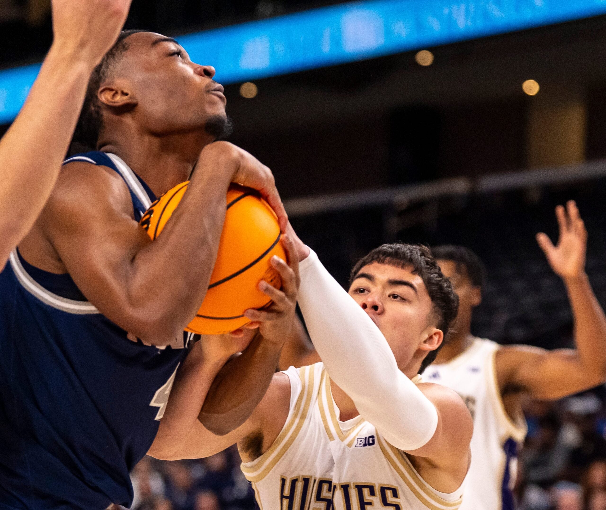 Nevada Wolf Pack guard Corey Camper Jr. (4) fights for a rebound against Washington Huskies guard JJ Mandaquit (23) during the first half of their game in the Acrisure Series in Palm Desert, Calif., Thursday, Nov. 27, 2025.