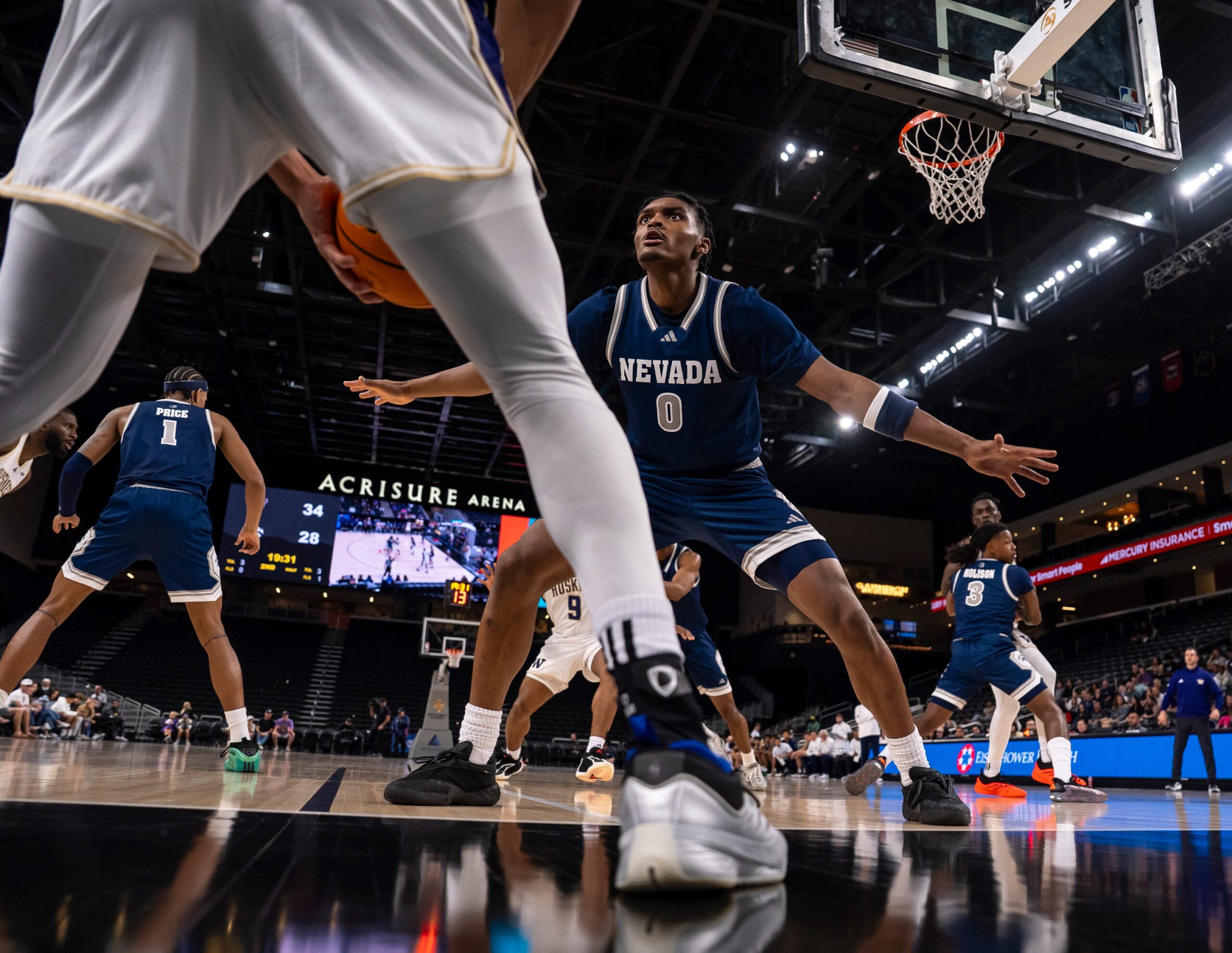 Nevada Wolf Pack guard Chuck Bailey III (0) defends a Washington Huskies players as he throws in the ball during the second half of their game in the Acrisure Series in Palm Desert, Calif., Thursday, Nov. 27, 2025.