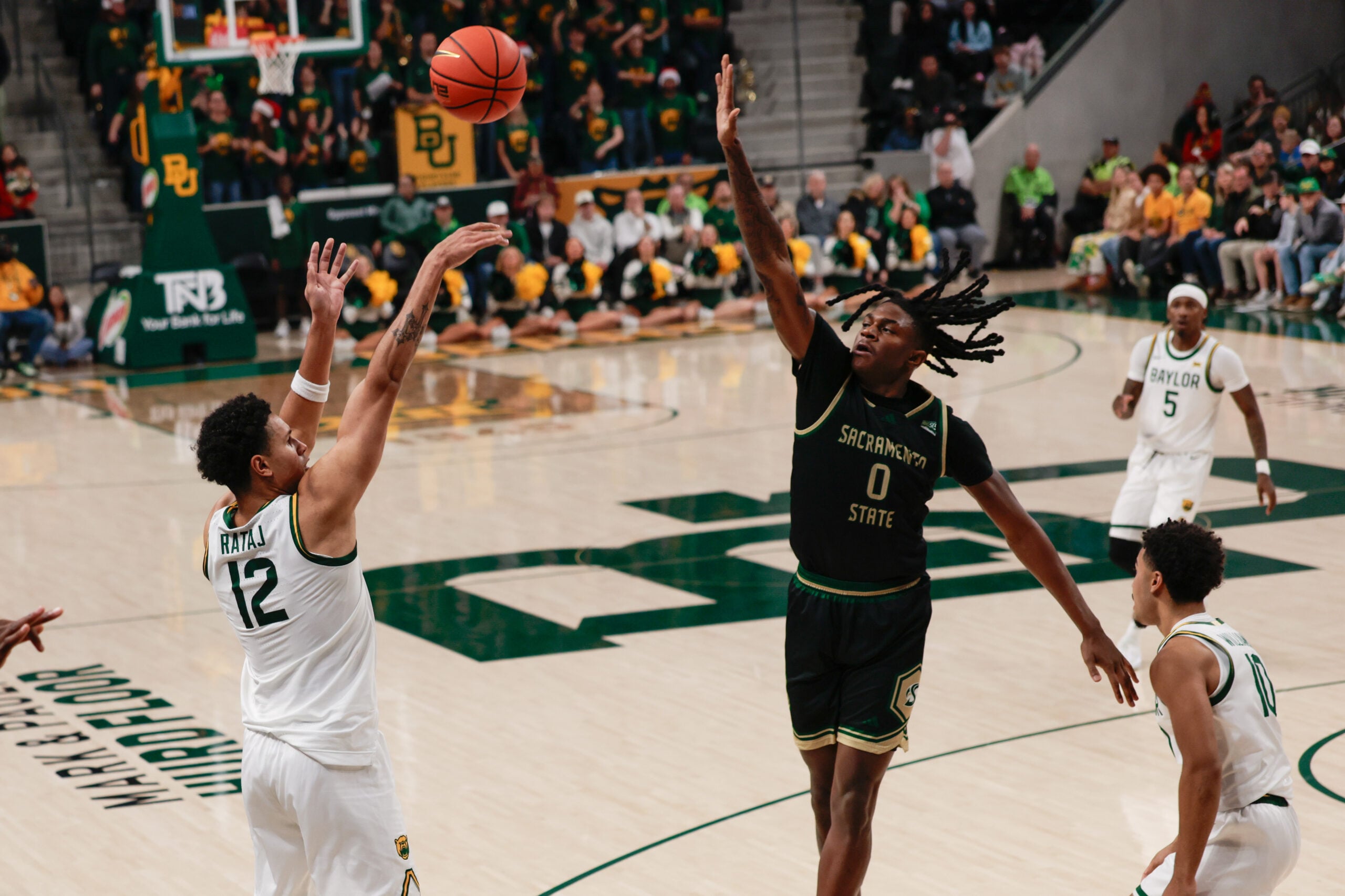 Dec 2, 2025; Waco, Texas, USA;  Baylor Bears guard Michael Rataj (12) scores a three-point basket against Sacramento State Hornets forward Brandon Gardner (0) during the second half at Paul and Alejandra Foster Pavilion. Mandatory Credit: Chris Jones-Imagn Images