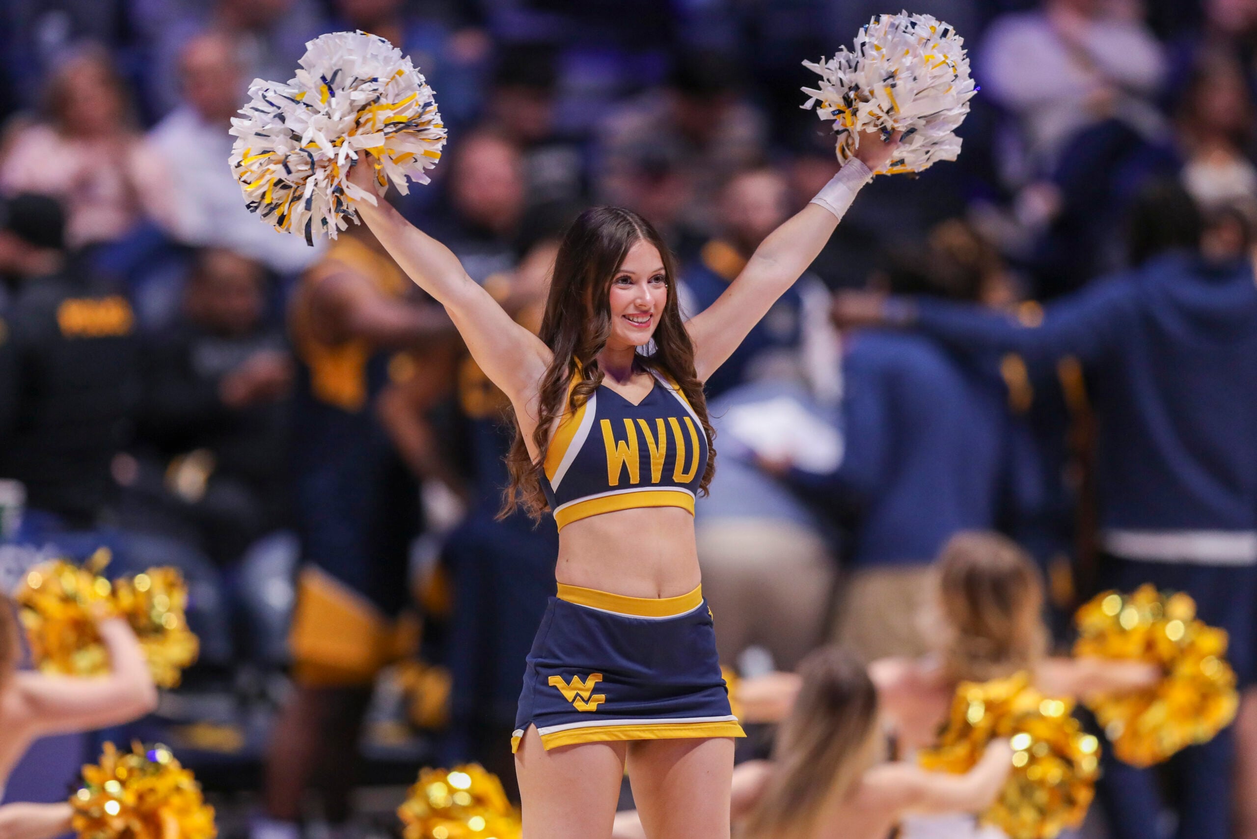 Dec 3, 2025; Morgantown, West Virginia, USA; A West Virginia Mountaineers cheerleader performs during the first half against the Coppin State Eagles at Hope Coliseum. Mandatory Credit: Ben Queen-Imagn Images