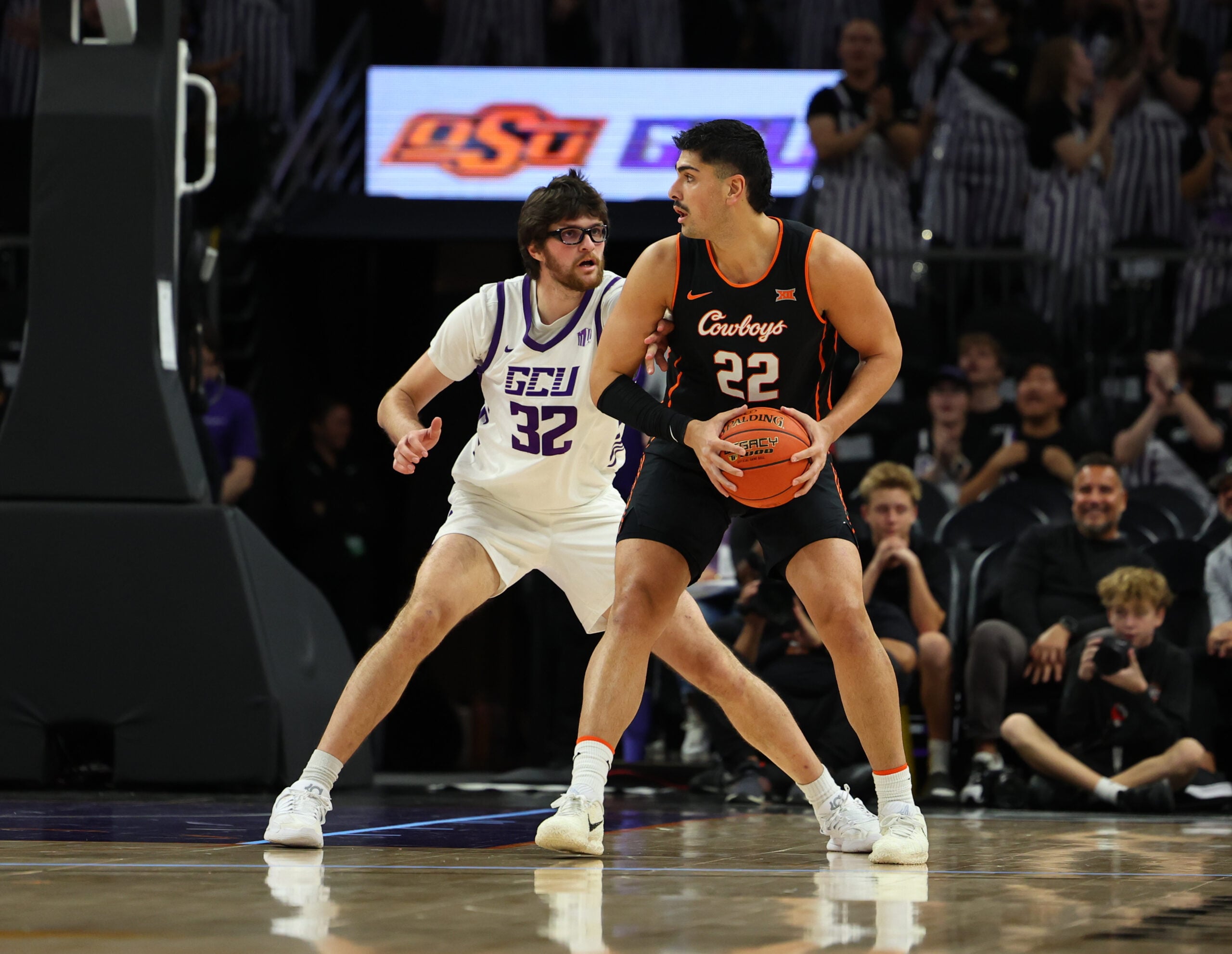 Dec 6, 2025; Phoenix, Arizona, USA; Grand Canyon Lopes forward Wilhelm Breidenbach (32) plays defense on Oklahoma State Cowboys forward Parsa Fallah (22) at PHX Arena. Mandatory Credit: Anna Carrington-Imagn Images