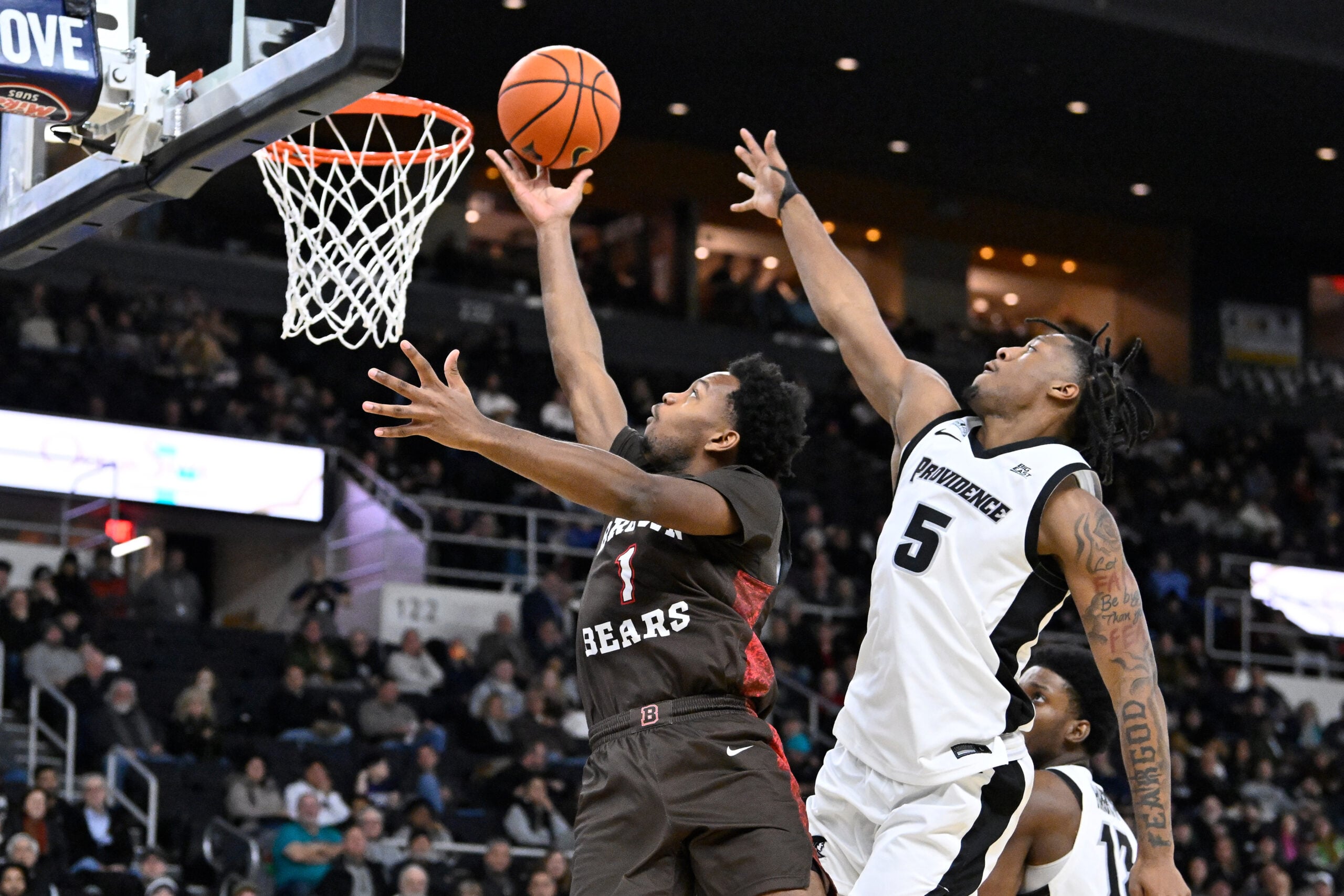 Dec 9, 2025; Providence, Rhode Island, USA; Brown Bears guard Isaiah Langham (1) shoots a layup through the defense of Providence Friars forward Jamier Jones (5) during the second half at Amica Mutual Pavilion. Mandatory Credit: Eric Canha-Imagn Images