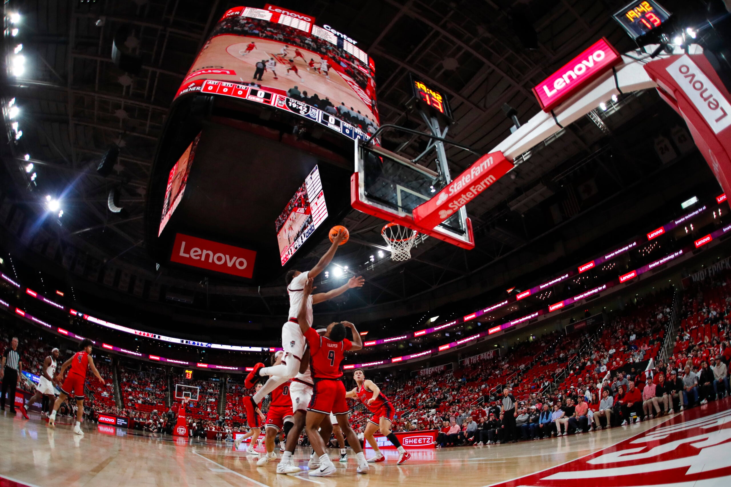 Dec 6, 2025; Raleigh, North Carolina, USA; NC State Wolfpack guard Quadir Copeland (11) dunks the ball past Liberty Flames guard JJ Harper (9) during the first half of the game at Lenovo Center. Mandatory Credit: Jaylynn Nash-Imagn Images