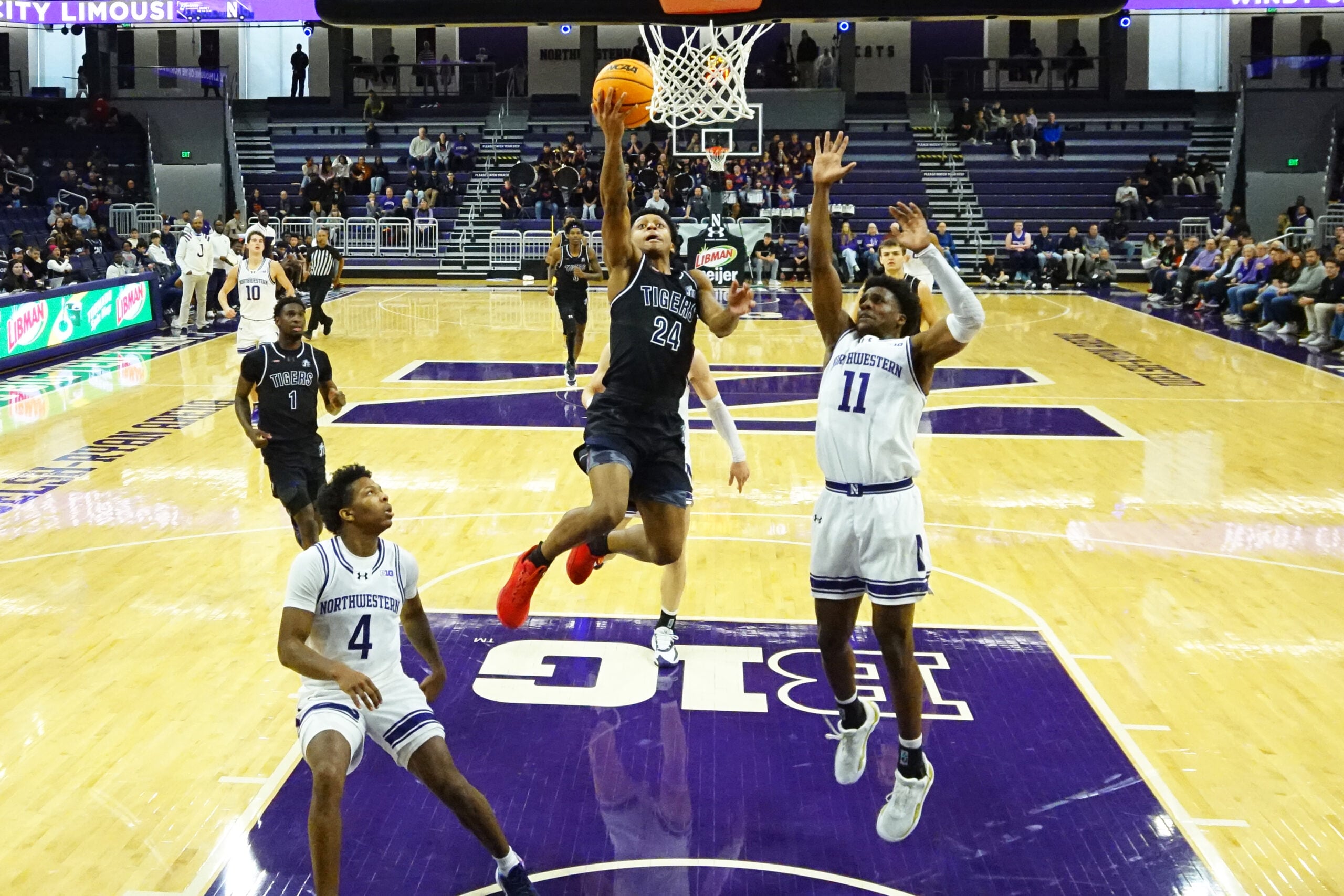 Dec 13, 2025; Evanston, Illinois, USA; Northwestern Wildcats guard Jordan Clayton (11) defends Jackson State Tigers guard Daeshun Ruffin (24) during the first half at Welsh-Ryan Arena. Mandatory Credit: David Banks-Imagn Images