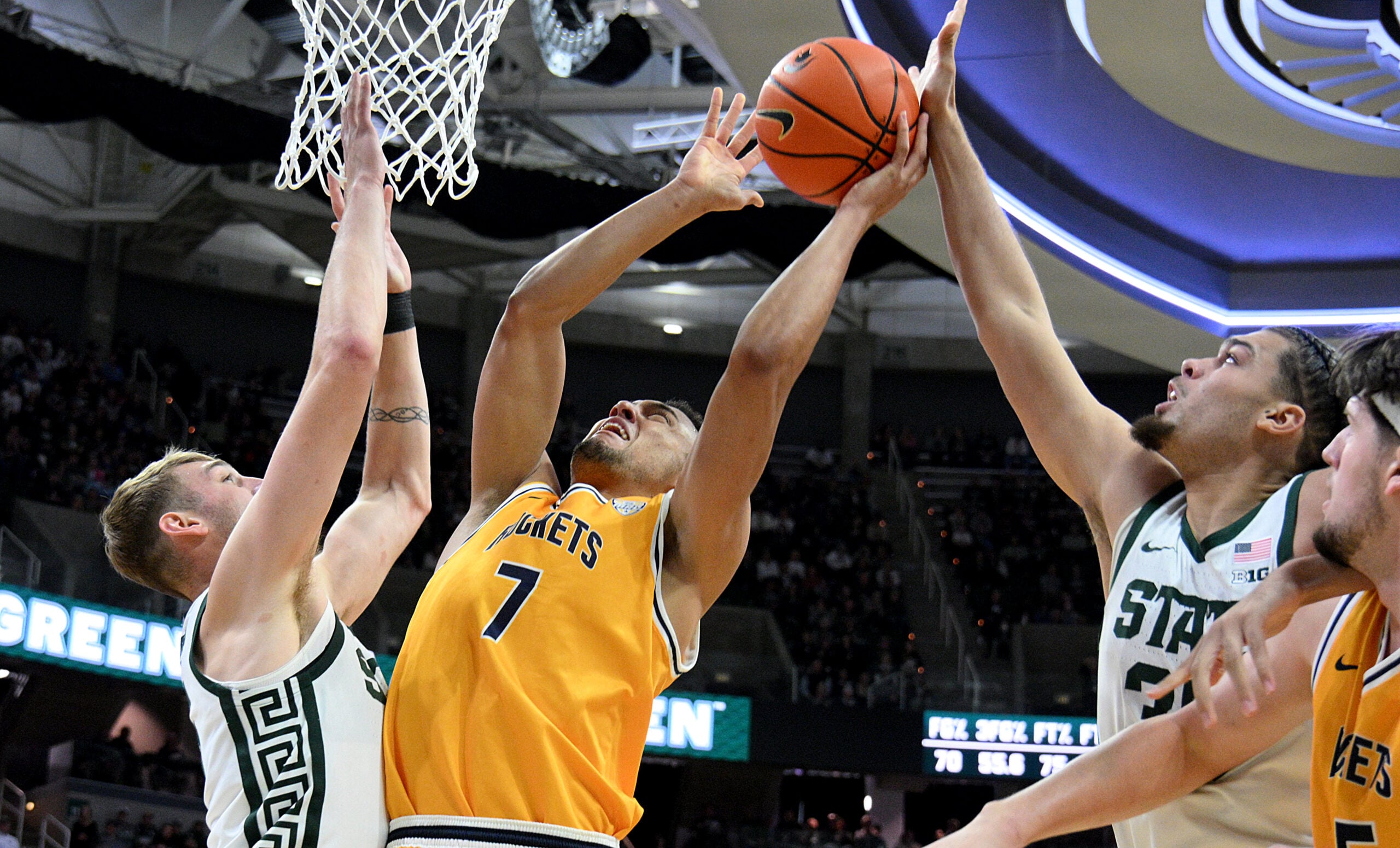 Dec 16, 2025; East Lansing, Michigan, USA;  Toledo Rockets forward Sean Craig (7) gets blocked by Michigan State Spartans forward Jesse McCulloch (35) during the first half at Jack Breslin Student Events Center. Mandatory Credit: Dale Young-Imagn Images