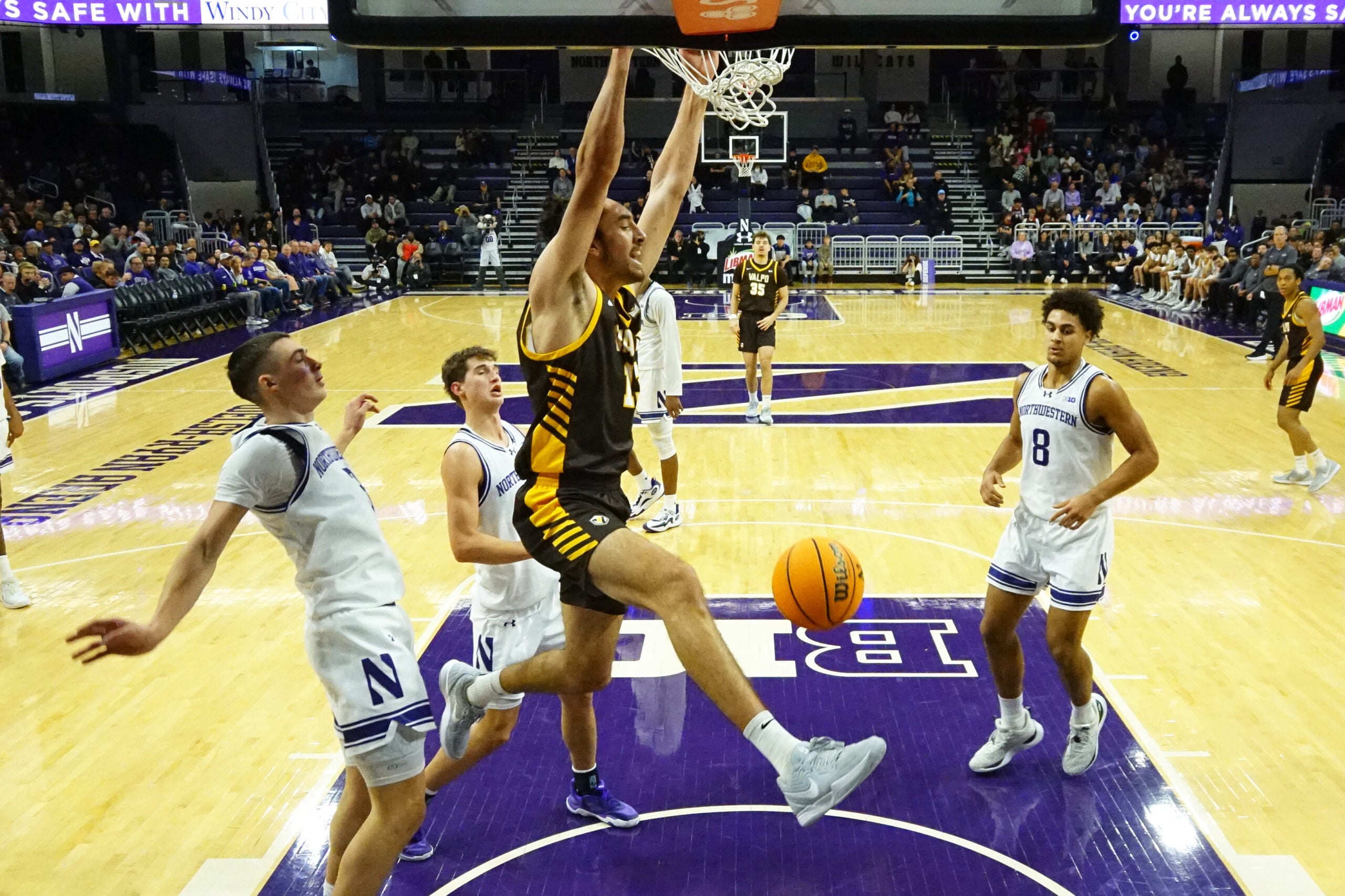 Dec 16, 2025; Evanston, Illinois, USA; Valparaiso Beacons forward Carter Hopoi (13) dunks the ball as Northwestern Wildcats forward Tre Singleton (8) stands nearby during the second half at Welsh-Ryan Arena. Mandatory Credit: David Banks-Imagn Images
