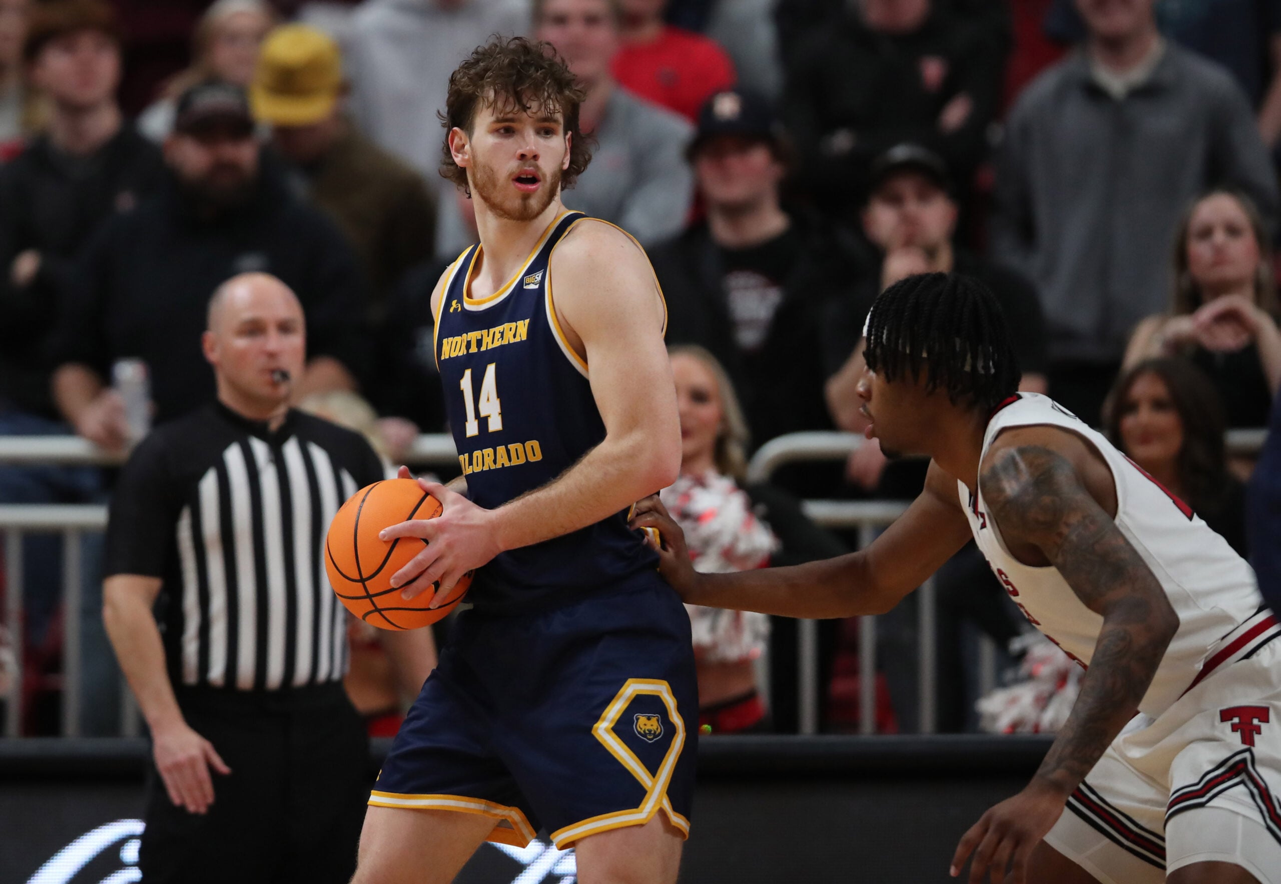 Dec 16, 2025; Lubbock, Texas, USA;  Northern Colorado Bears forward Brock Wisne (14) holds the ball in front of Texas Tech Red Raiders forward JT Toppin (15) in the second half at United Supermarkets Arena. Mandatory Credit: Michael C. Johnson-Imagn Images