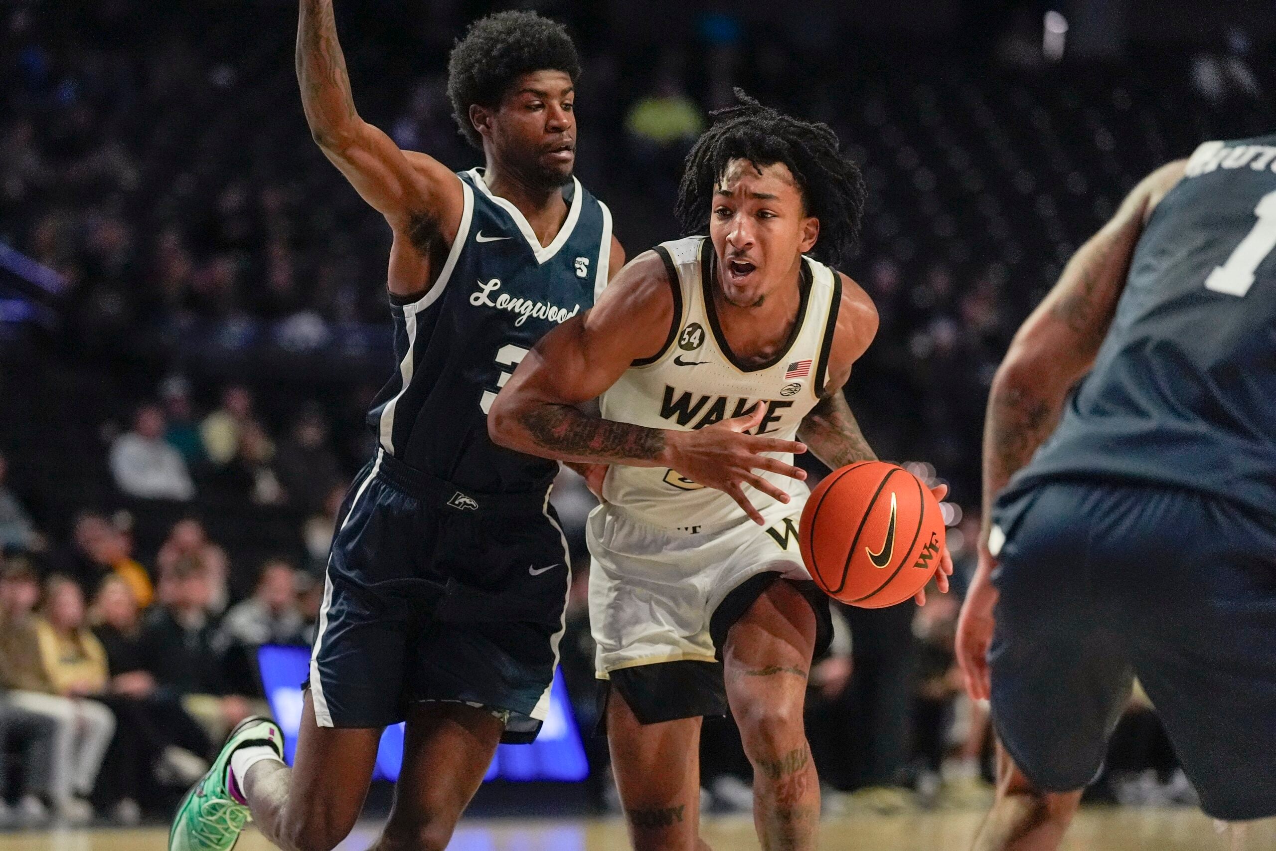 Dec 17, 2025; Winston-Salem, North Carolina, USA; Wake Forest Demon Deacons guard Juke Harris (2) handles the ball defended by Longwood Lancers guard Alphonzo Billups III (3) during the first half at Lawrence Joel Veterans Memorial Coliseum. Mandatory Credit: Jim Dedmon-Imagn Images