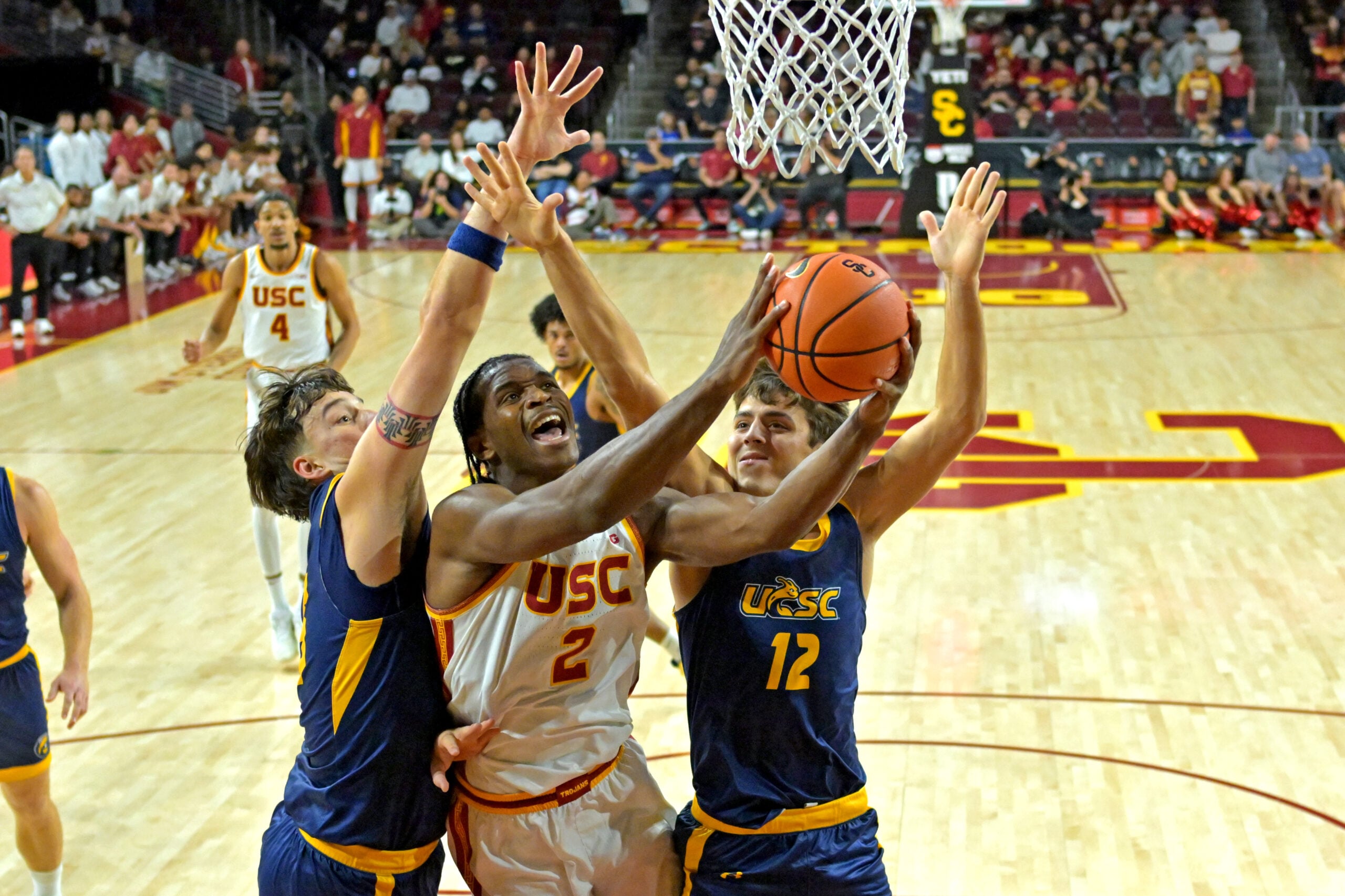 Dec 21, 2025; Los Angeles, California, USA; USC Trojans forward Ezra Ausar (2) is defended by UC Santa Cruz Banana Slugs center Joseph Espy (55) and guard Thomas Conley (12) as he drives to the basket in the first half at Galen Center. Mandatory Credit: Jayne Kamin-Oncea-Imagn Images